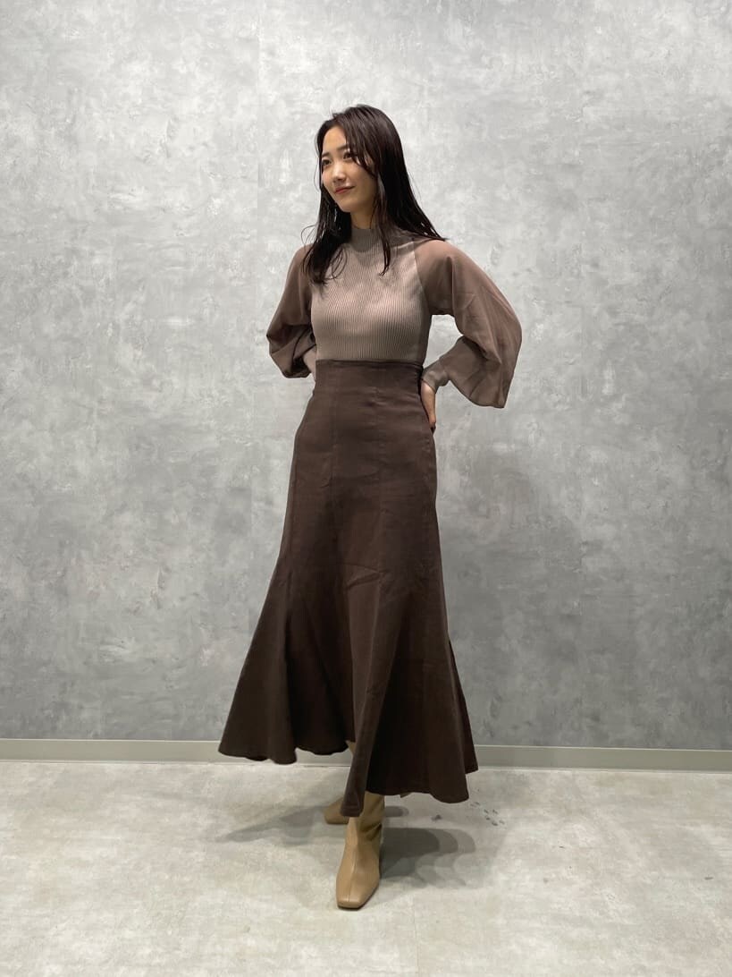 ベージュ系のブーツ、ブラウン系のスカート、ベージュ系のニット/セーターを着用したレディースの秋コーディネートの2枚目の写真