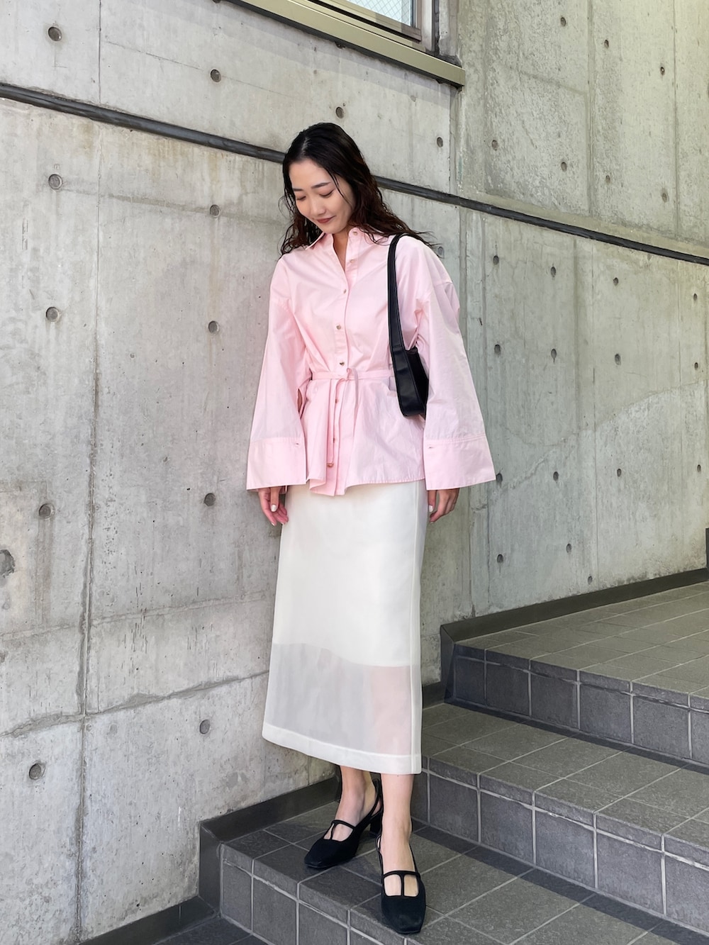 ピンク系のシャツ/ブラウス、ブラック系のパンプス、ホワイト系のスカートを着用したレディースの冬コーディネートの6枚目の写真