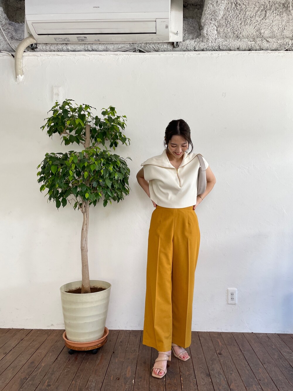 ベージュ系のサンダル、ホワイト系のニット/セーター、イエロー系のスラックスを着用したレディースの春コーディネートの3枚目の写真