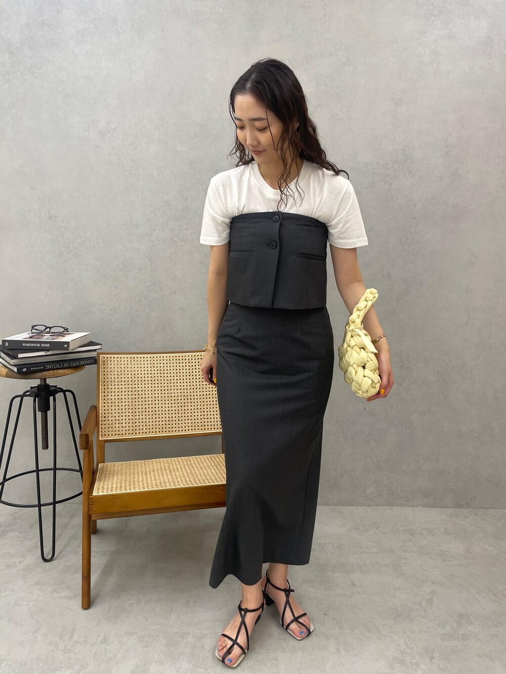 グレー系のスカート、ホワイト系のTシャツ/カットソー、ベージュ系のハンドバッグを着用したレディースの春コーディネートの3枚目の写真