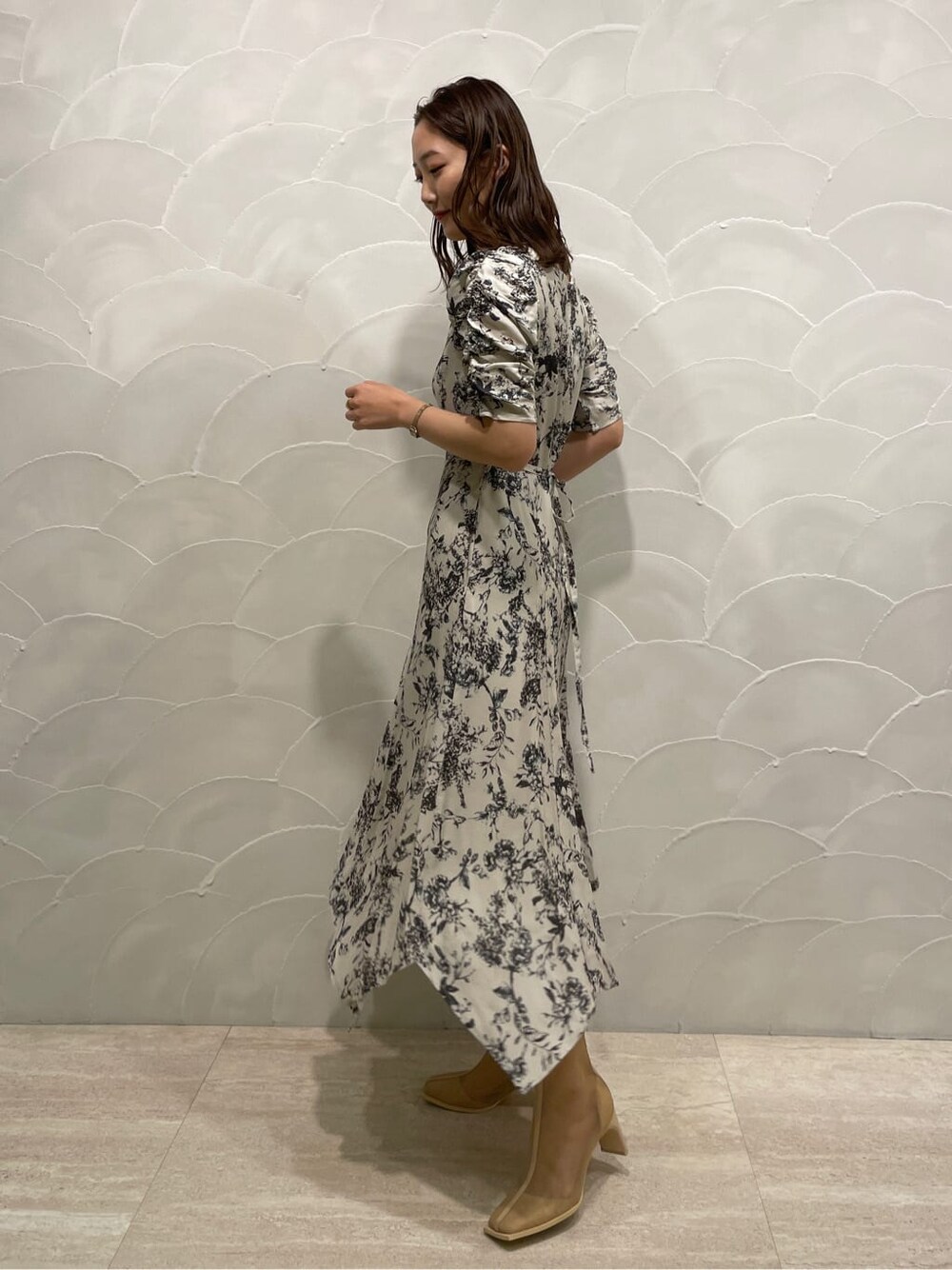 パープル系のテーラードジャケット、ベージュ系のブーツ、グレー系のワンピースを着用したレディースの春コーディネートの5枚目の写真