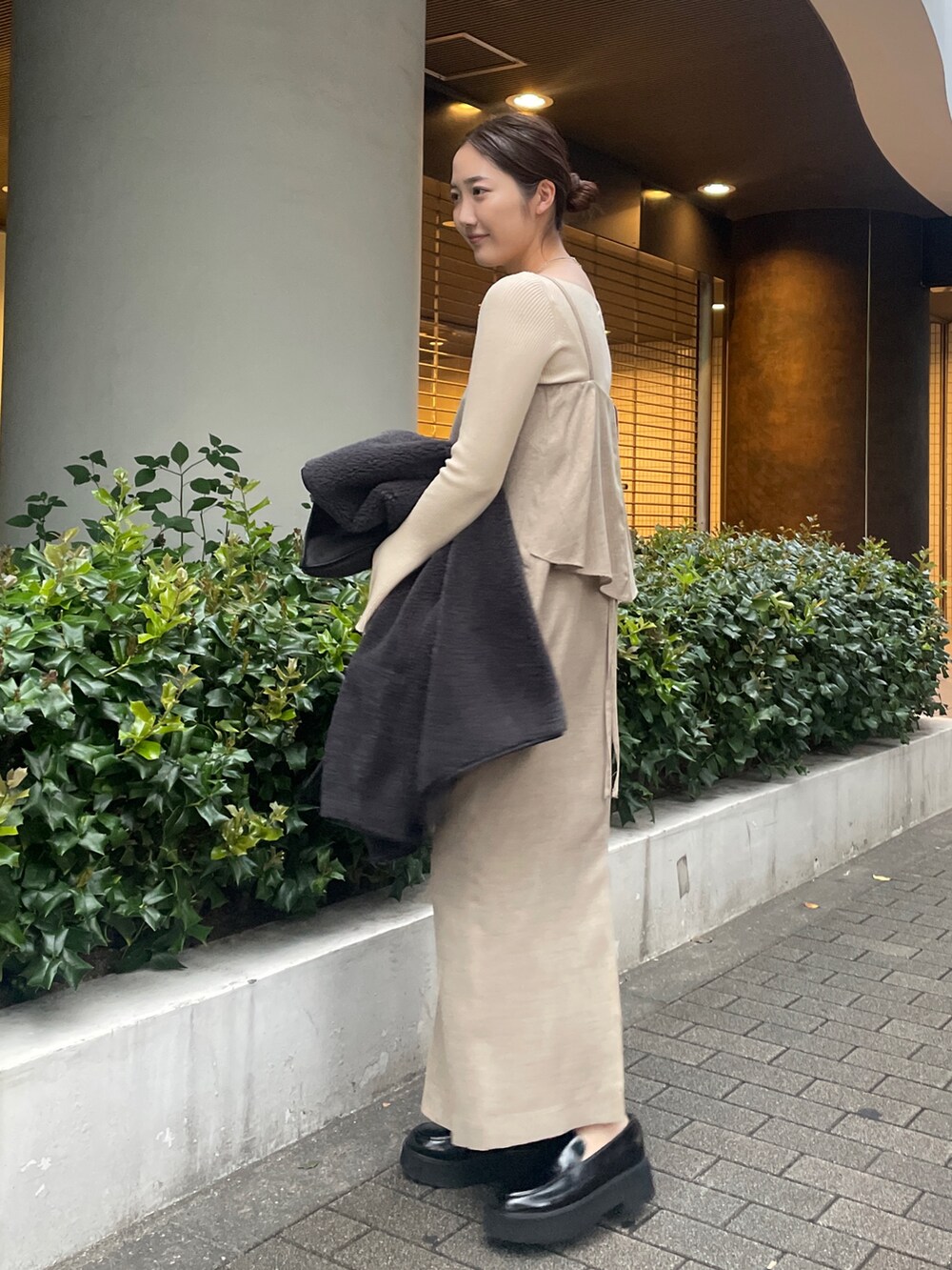 ベージュ系のワンピース、ホワイト系のニット/セーター、ブラック系のローファーを着用したレディースの秋コーディネートの4枚目の写真