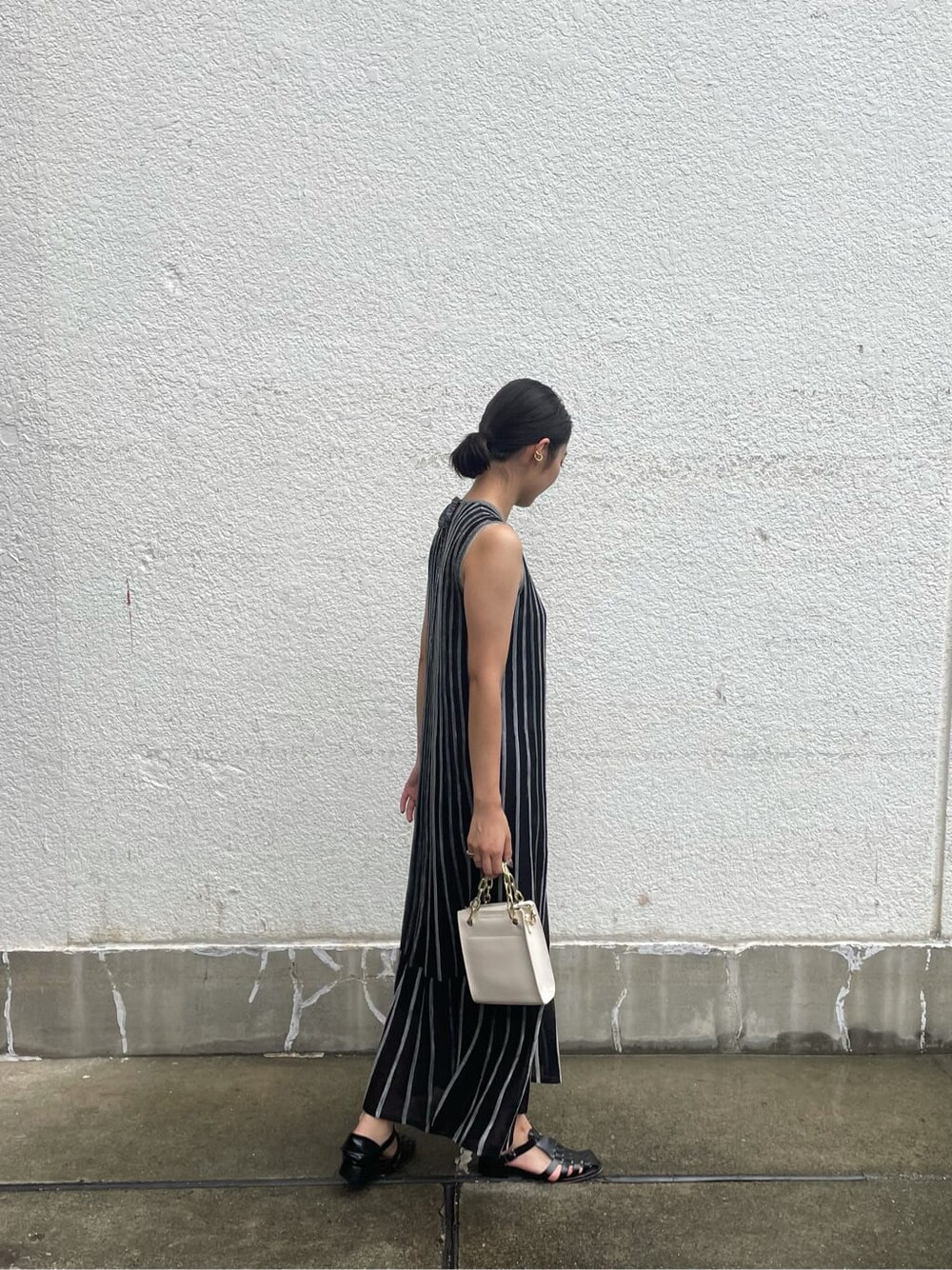 ブラック系のワンピース、ホワイト系のショルダーバッグを着用したレディースの夏コーディネートの2枚目の写真