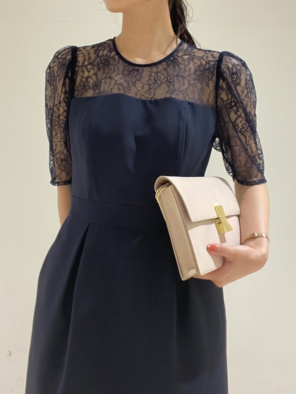 ゴールド系のクラッチバッグ、ベージュ系のパンプス、ブルー系のドレスを着用したレディースの春コーディネートの9枚目の写真