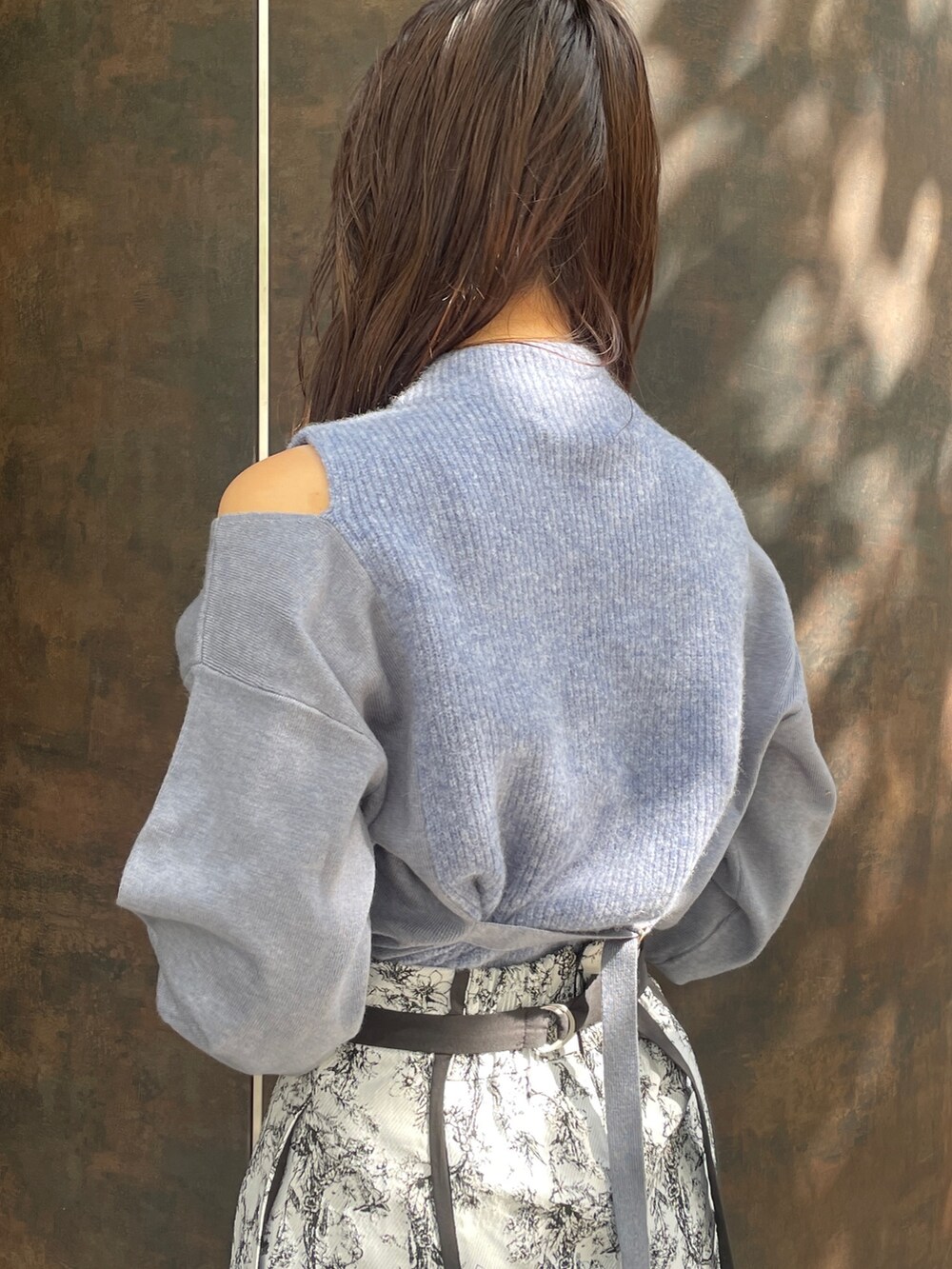 ブラック系のハンドバッグ、ブラック系のスカート、ブラック系のブーツを着用したレディースの秋コーディネートの7枚目の写真