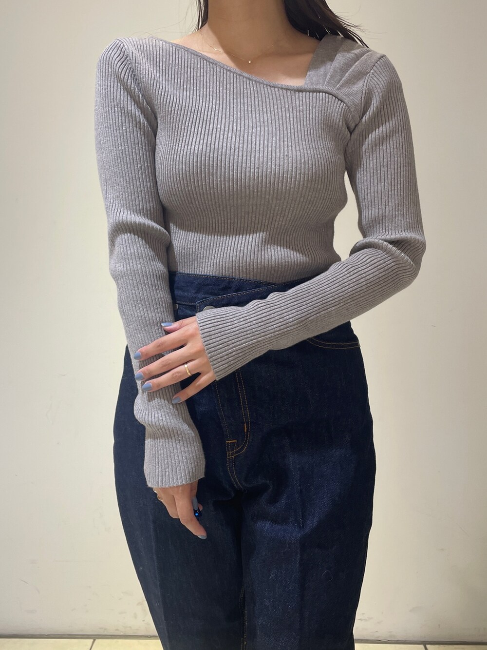 ホワイト系のノーカラーコート、グレー系のニット/セーター、ブルー系のデニムパンツを着用したレディースの秋コーディネートの8枚目の写真