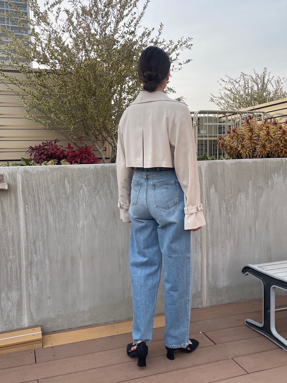 ブルー系のデニムパンツ、ホワイト系のトレンチコート、グリーン系のニット/セーターを着用したレディースの冬コーディネートの4枚目の写真