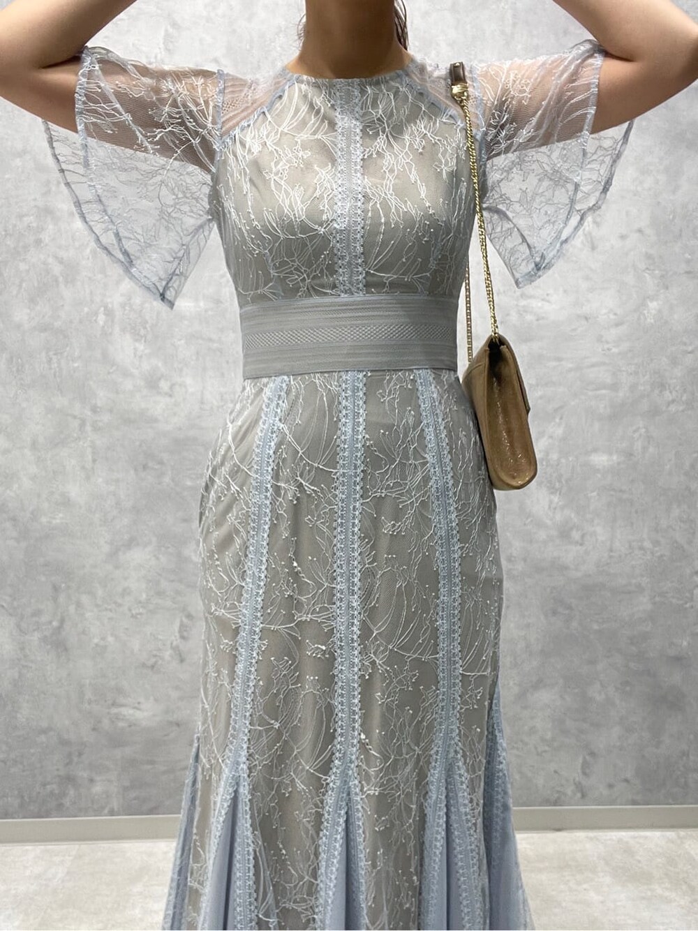 ゴールド系のクラッチバッグ、ベージュ系のパンプス、ブルー系のドレスを着用したレディースの春コーディネートの7枚目の写真