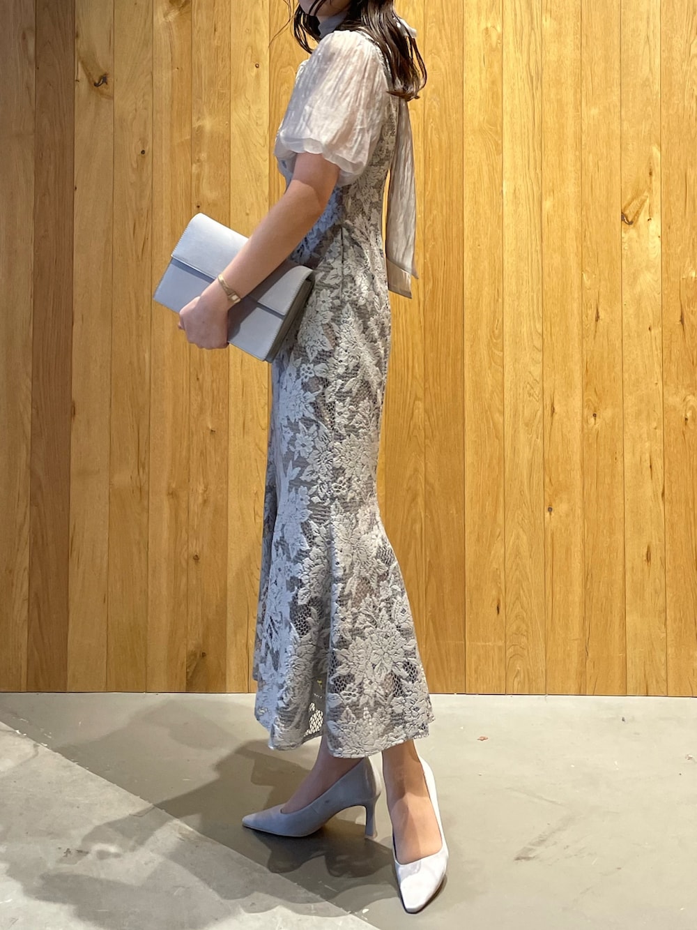グレー系のパンプス、グレー系のクラッチバッグ、グレー系のドレスを着用したレディースの冬コーディネートの4枚目の写真