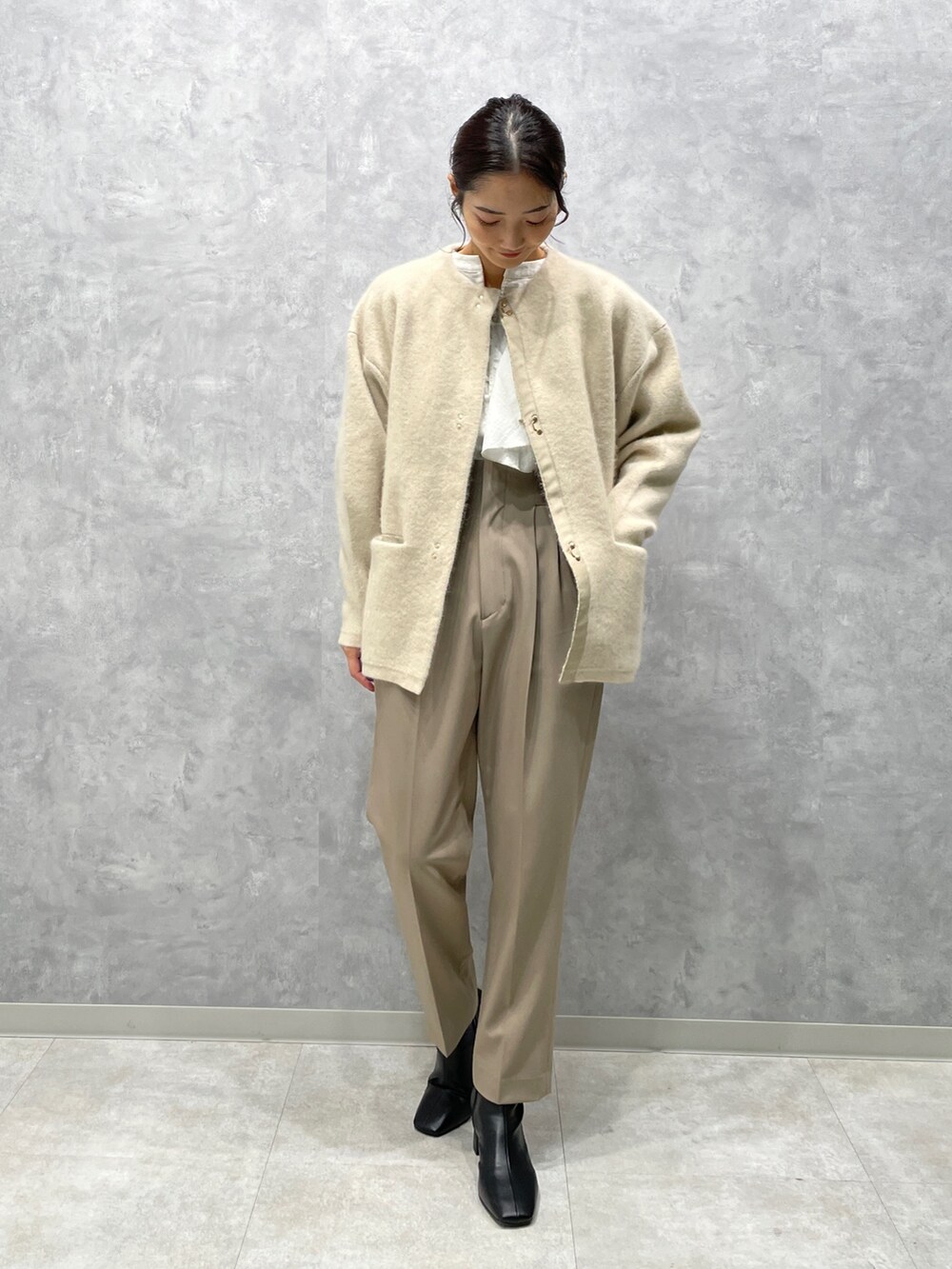 ホワイト系のカーディガン/ボレロ、ブラック系のブーツ、ホワイト系のシャツ/ブラウスを着用したレディースの冬コーディネートの2枚目の写真