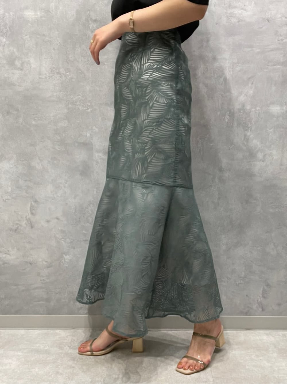 ブラック系のシャツ/ブラウス、グリーン系のサンダル、ブルー系のスカートを着用したレディースの夏コーディネートの8枚目の写真