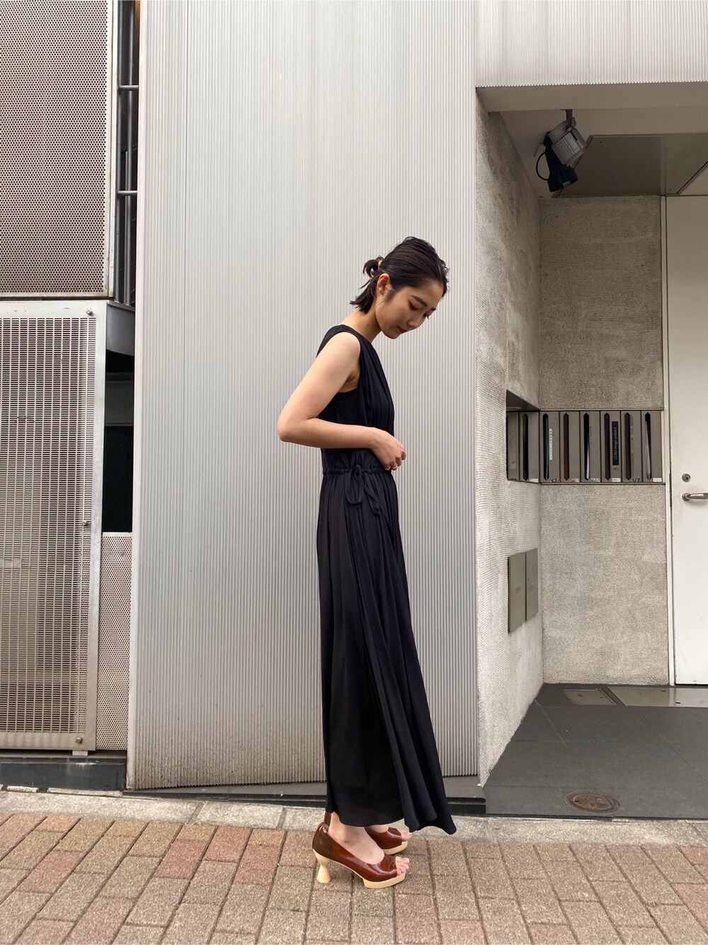 ブラウン系のパンプス、グレー系のカーディガン/ボレロ、ブラック系のワンピースを着用したレディースの春コーディネートの5枚目の写真