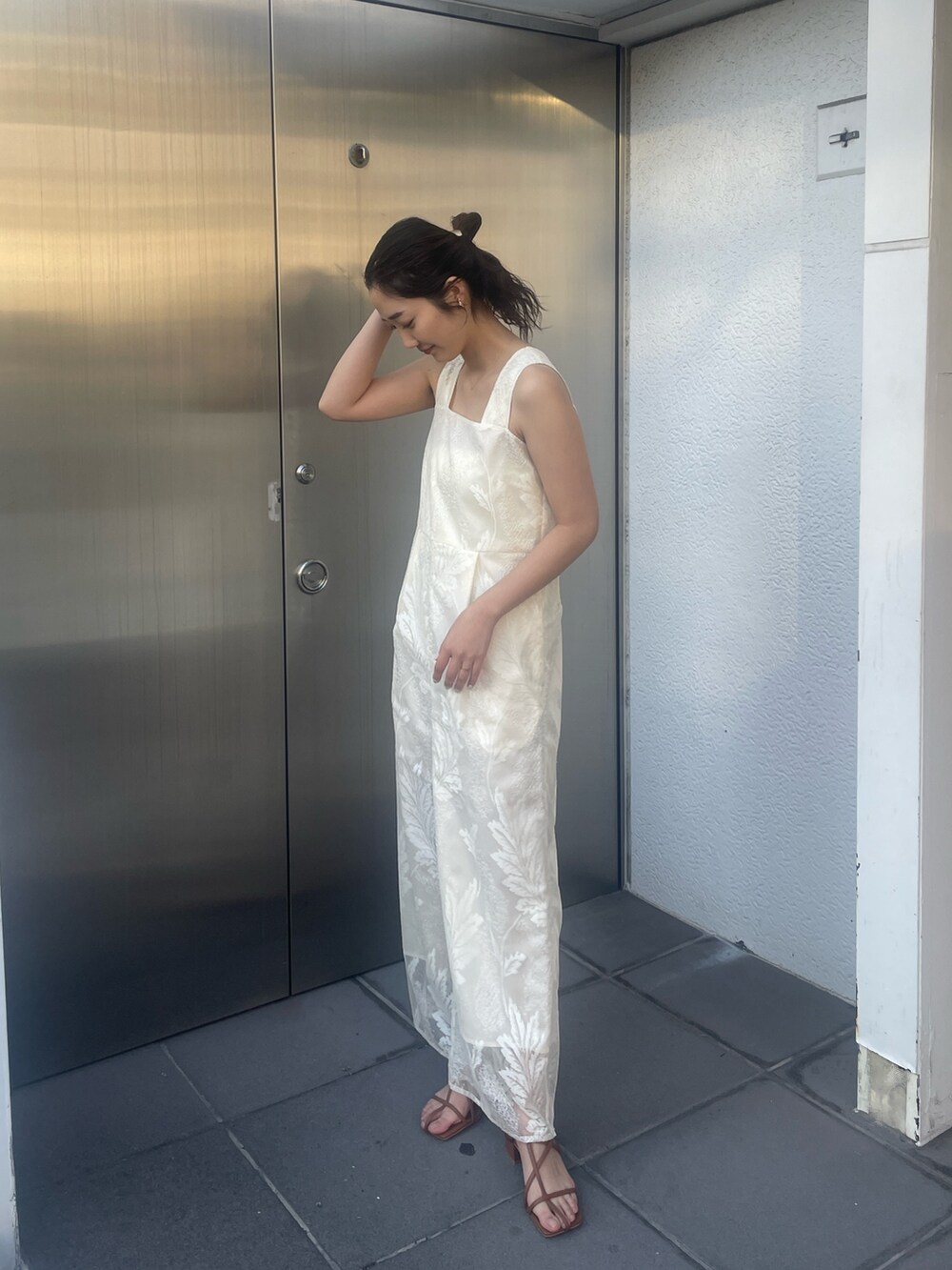 ブラウン系のサンダル、ホワイト系のつなぎ/オールインワン、ベージュ系の折りたたみ傘を着用したレディースの冬コーディネートの4枚目の写真