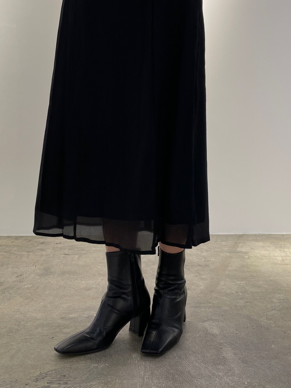 ブラック系のドレス、ブラック系のブーツを着用したレディースの冬コーディネートの8枚目の写真