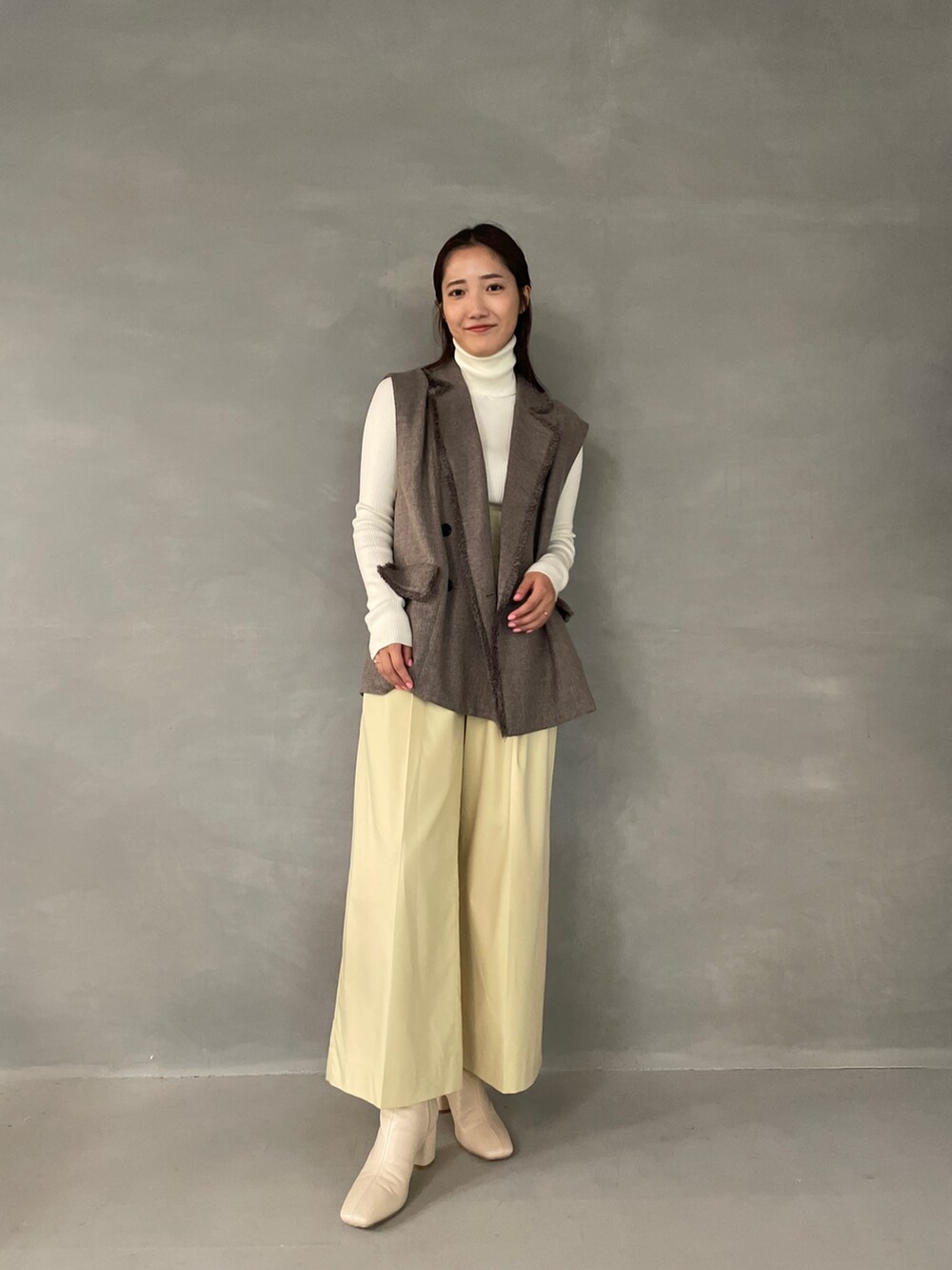 イエロー系のその他パンツ、ホワイト系のブーツ、グレー系のベストを着用したレディースの夏コーディネートの3枚目の写真