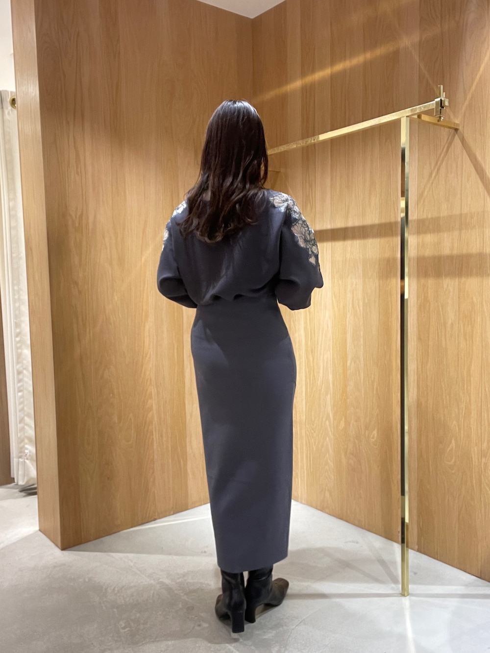 グレー系のスカート、グレー系のニット/セーター、ブラック系のブーツを着用したレディースの秋コーディネートの6枚目の写真