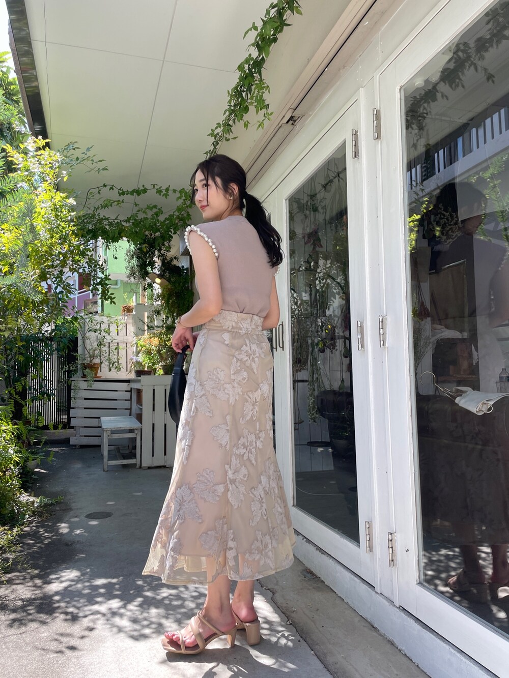 ベージュ系のサンダル、ベージュ系のニット/セーター、ベージュ系のスカートを着用したレディースの春コーディネートの4枚目の写真