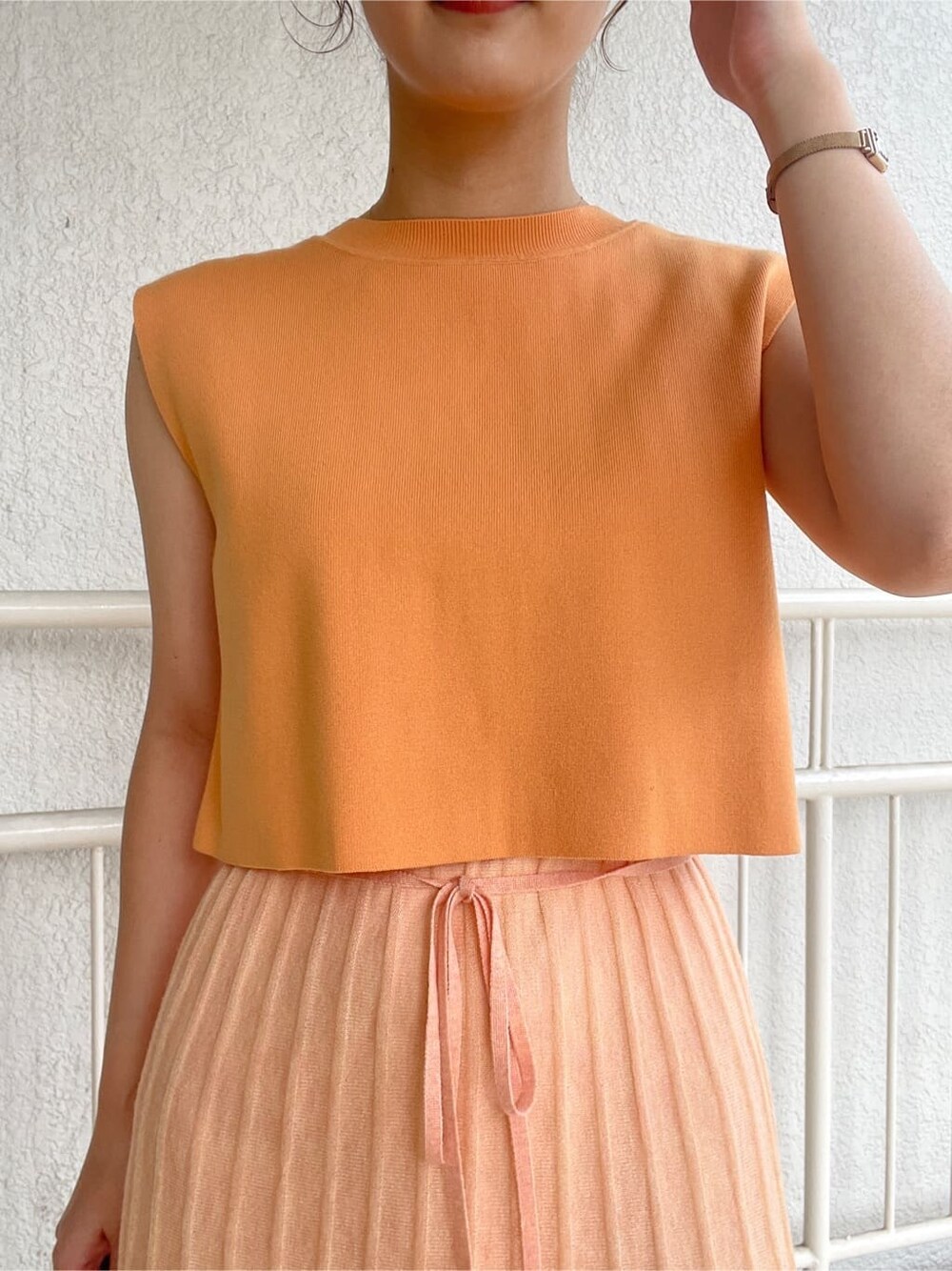 ベージュ系のブーツ、ベージュ系のテーラードジャケット、オレンジ系のワンピースを着用したレディースの春コーディネートの8枚目の写真