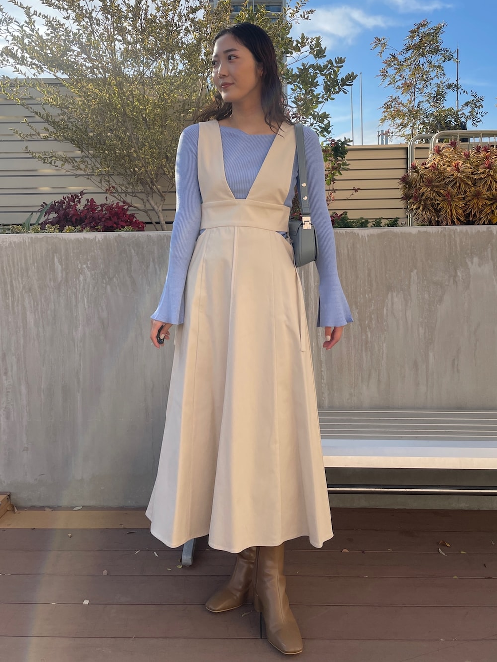 ブルー系のニット/セーター、ベージュ系のブーツ、ホワイト系のジャンパースカートを着用したレディースの冬コーディネートの2枚目の写真