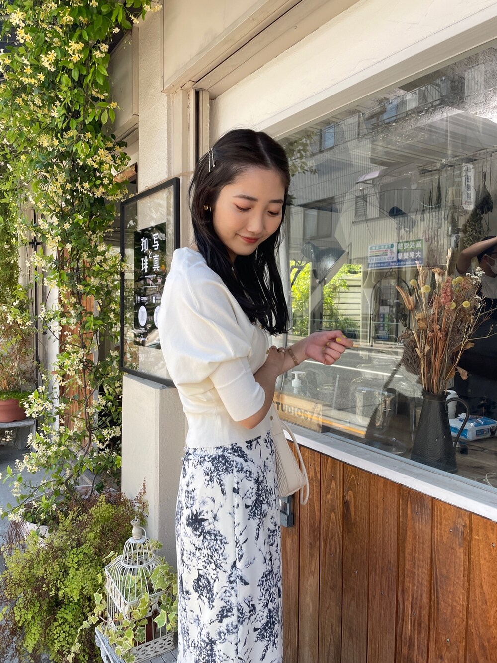 ベージュ系のハンドバッグ、ホワイト系のカーディガン/ボレロ、ブルー系のスカートを着用したレディースの春コーディネートの6枚目の写真