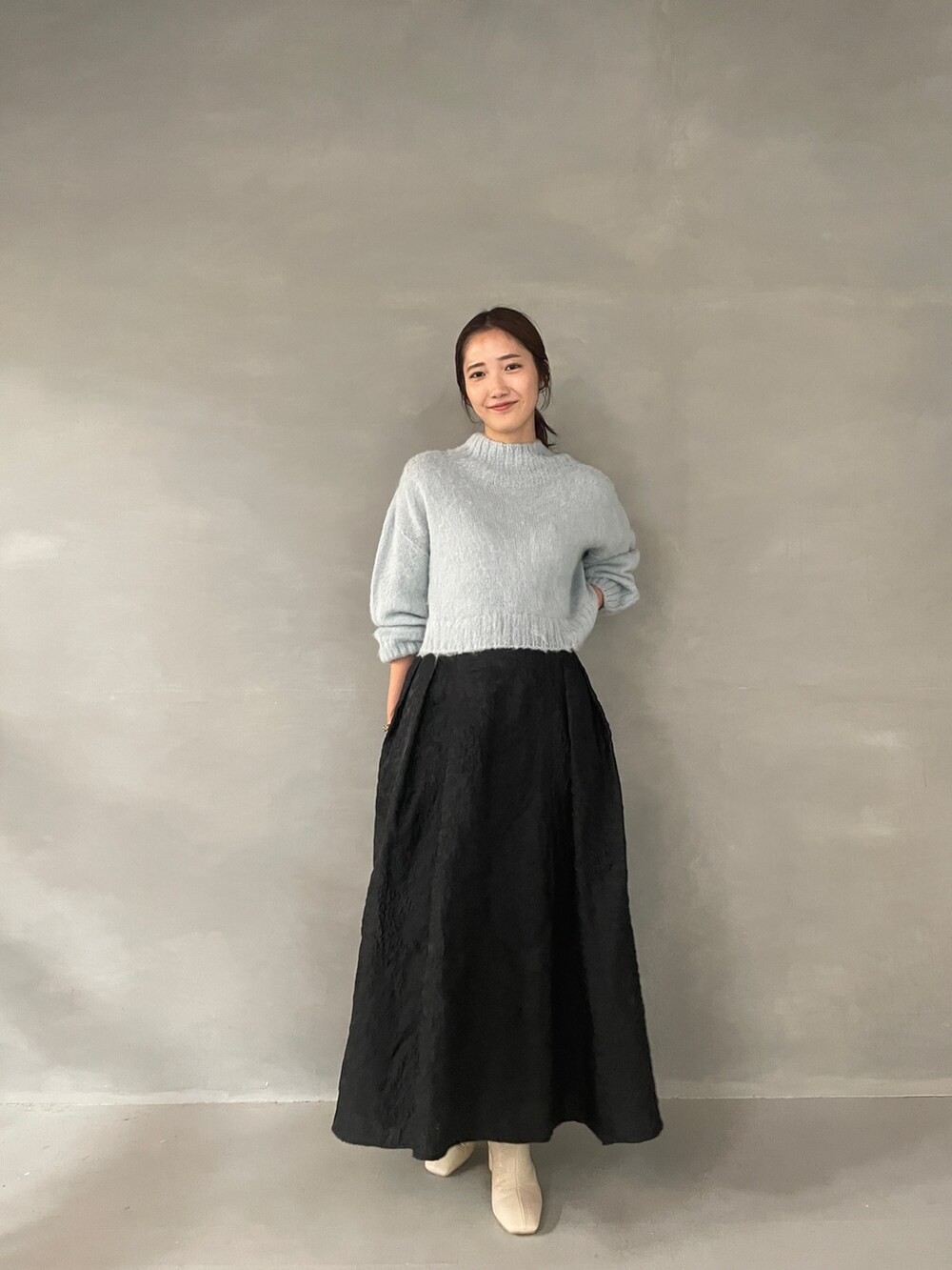 ホワイト系のブーツ、ブラック系のスカート、グリーン系のニット/セーターを着用したレディースの夏コーディネートの5枚目の写真