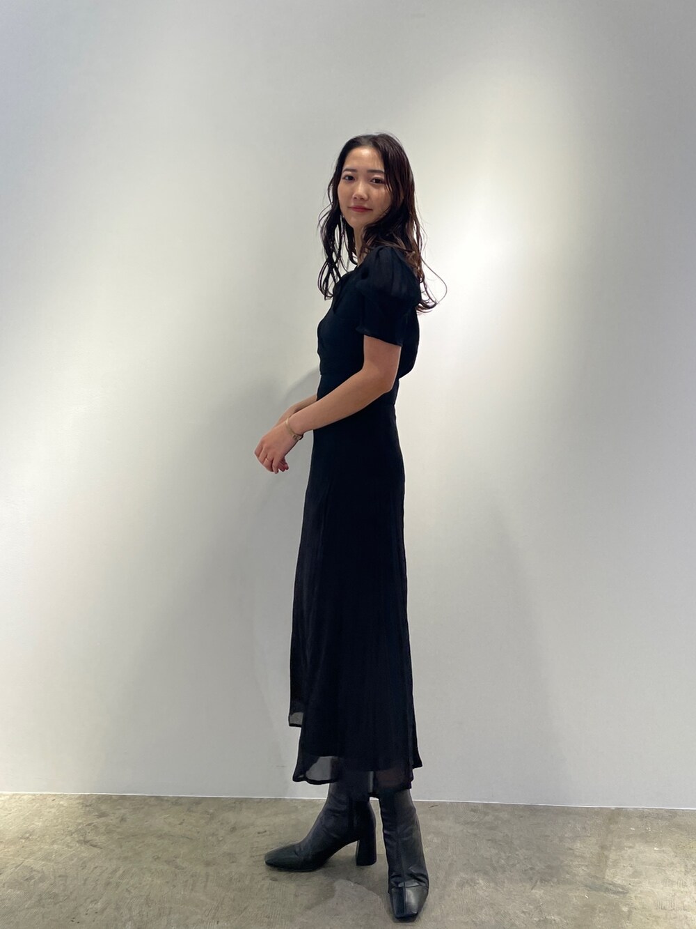 ブラック系のドレス、ブラック系のブーツを着用したレディースの冬コーディネートの3枚目の写真