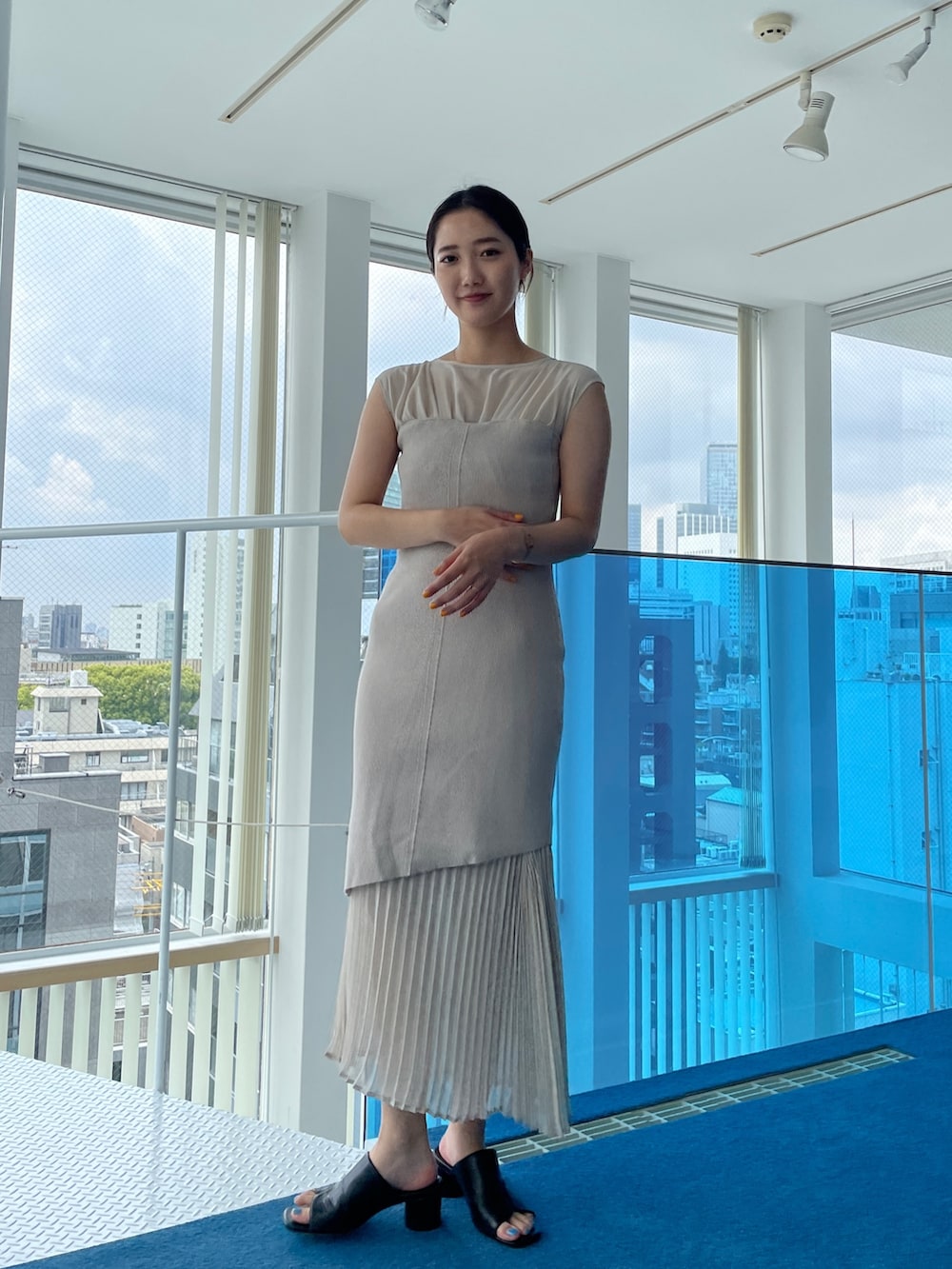 ブラック系のサンダル、ベージュ系のワンピースを着用したレディースの春コーディネートの2枚目の写真