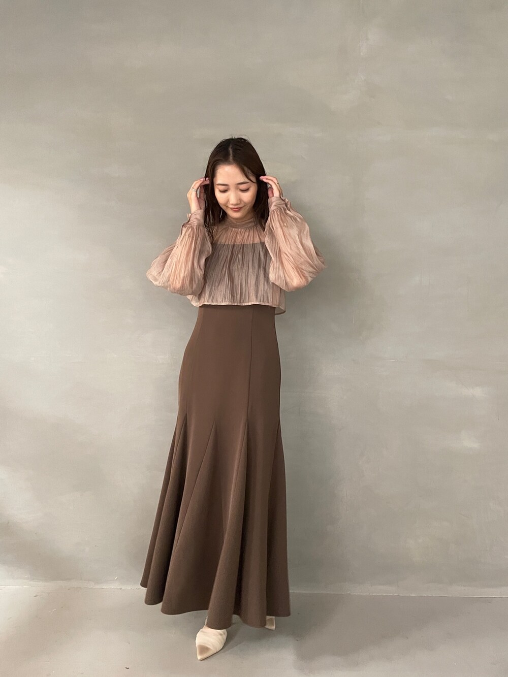 ベージュ系のパンプス、ブラウン系のドレスを着用したレディースの夏コーディネートの2枚目の写真