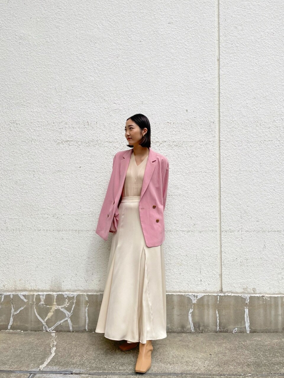 ホワイト系のスカート、ベージュ系のブーツ、ピンク系のテーラードジャケットを着用したレディースの春コーディネートの3枚目の写真