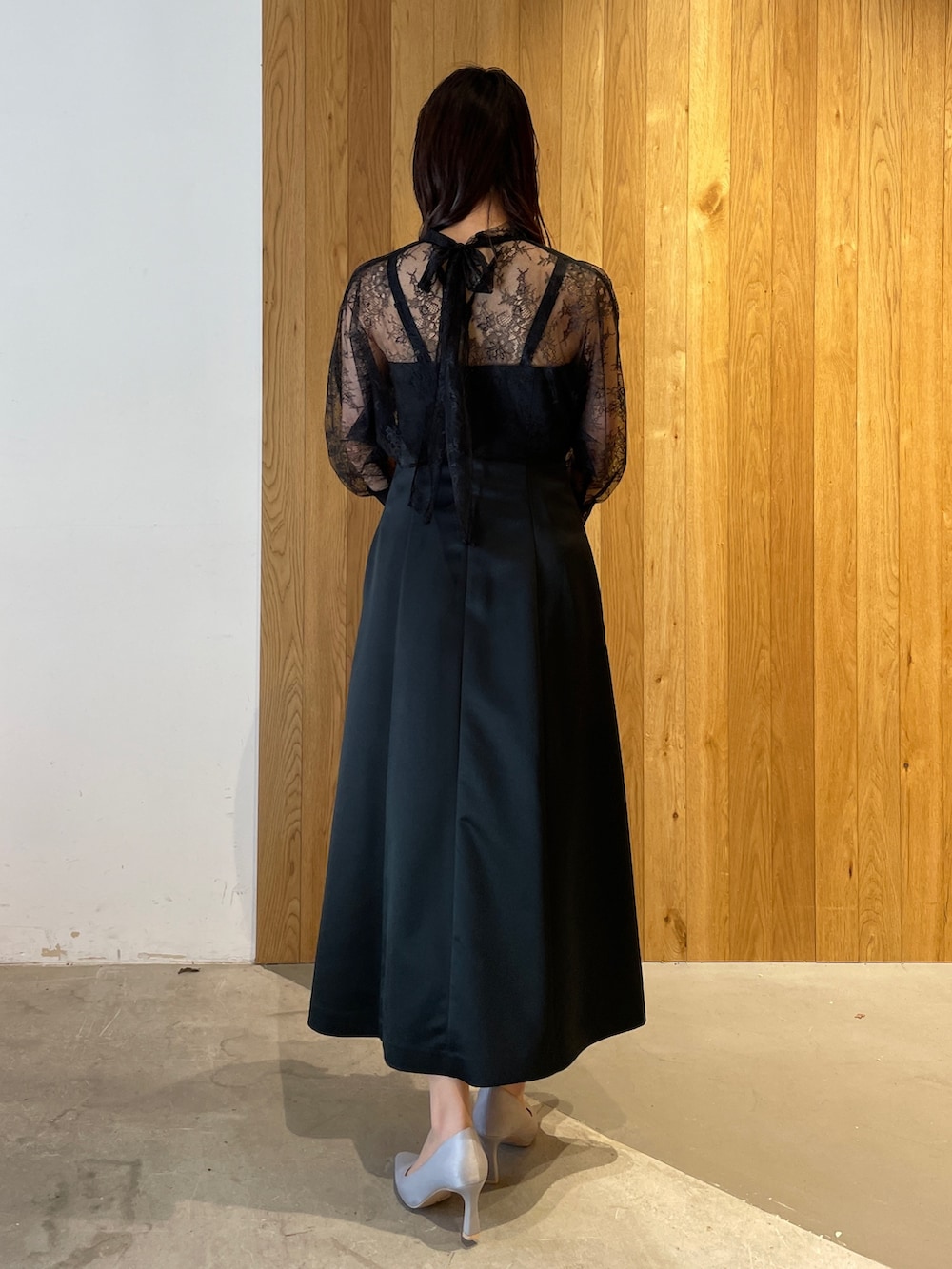 グレー系のパンプス、ブラック系のドレス、グレー系のクラッチバッグを着用したレディースの冬コーディネートの3枚目の写真