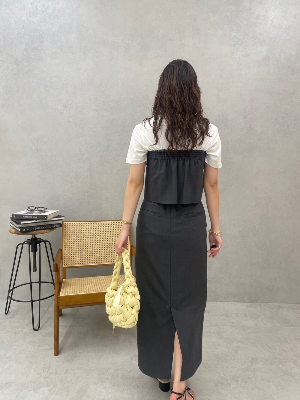 グレー系のスカート、ホワイト系のTシャツ/カットソー、ベージュ系のハンドバッグを着用したレディースの春コーディネートの6枚目の写真