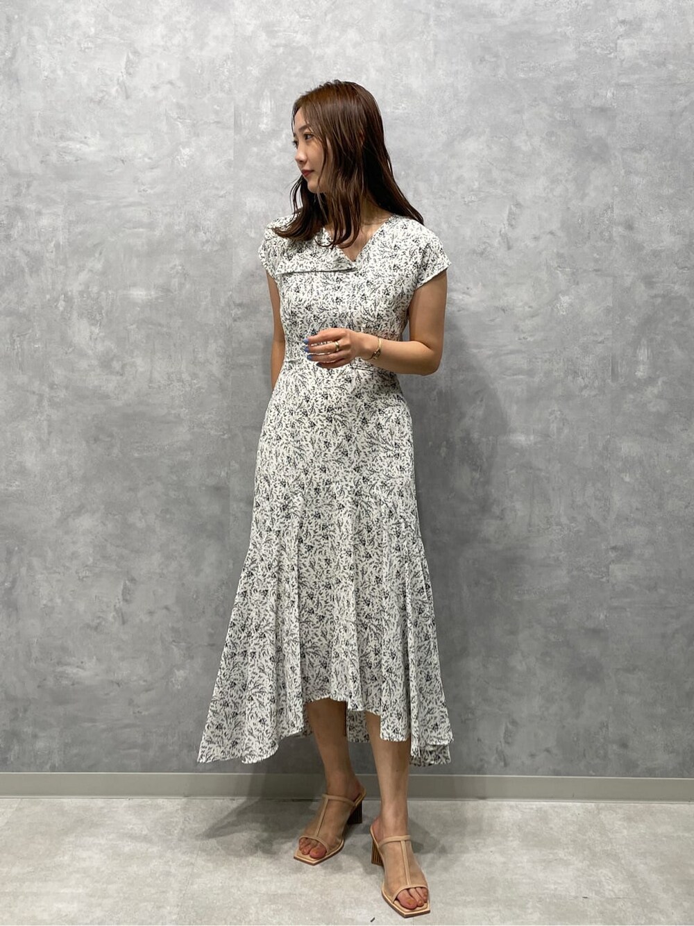 ベージュ系のサンダル、ホワイト系のワンピースを着用したレディースの夏コーディネートの2枚目の写真