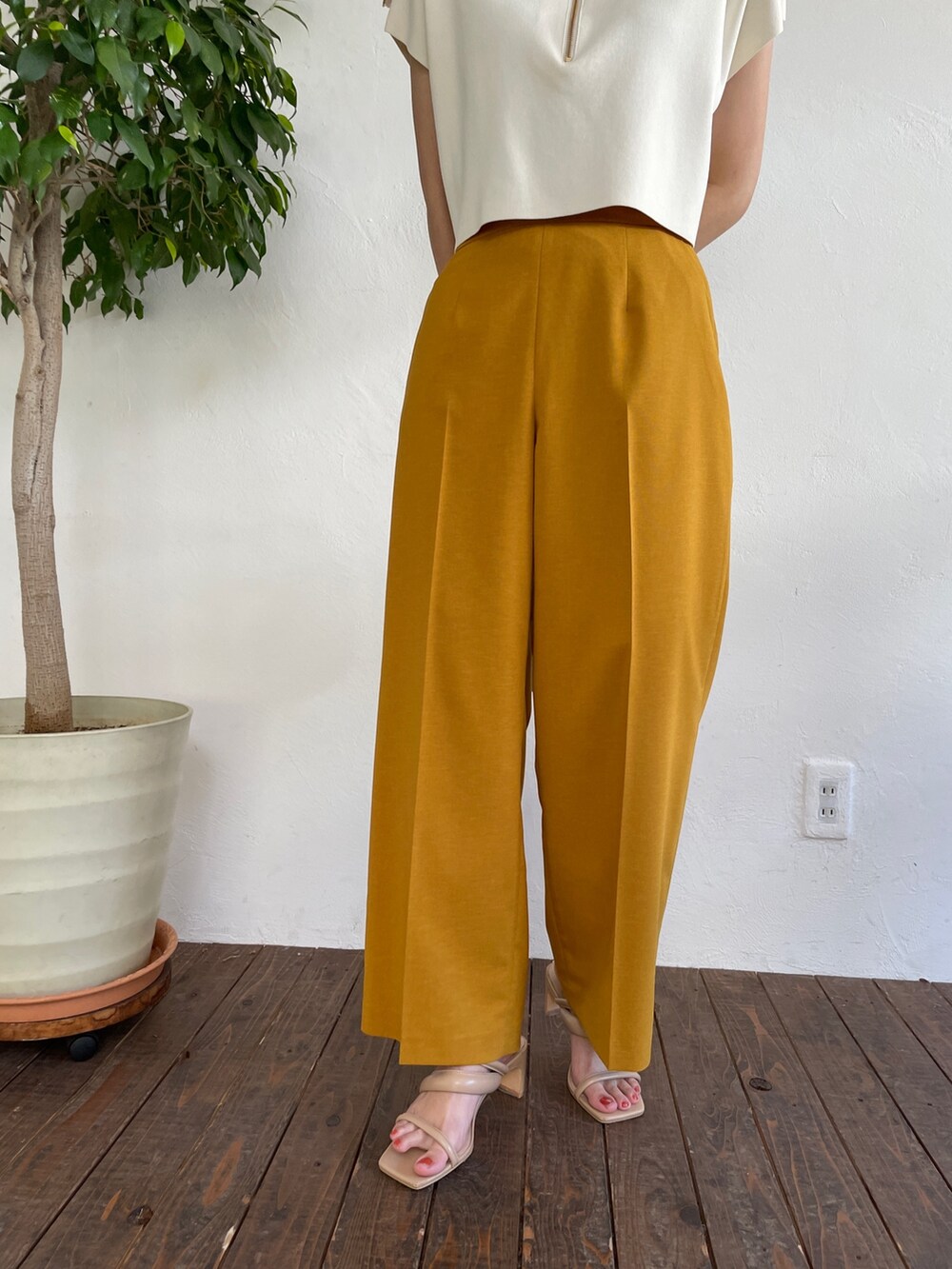 ベージュ系のサンダル、ホワイト系のニット/セーター、イエロー系のスラックスを着用したレディースの春コーディネートの7枚目の写真