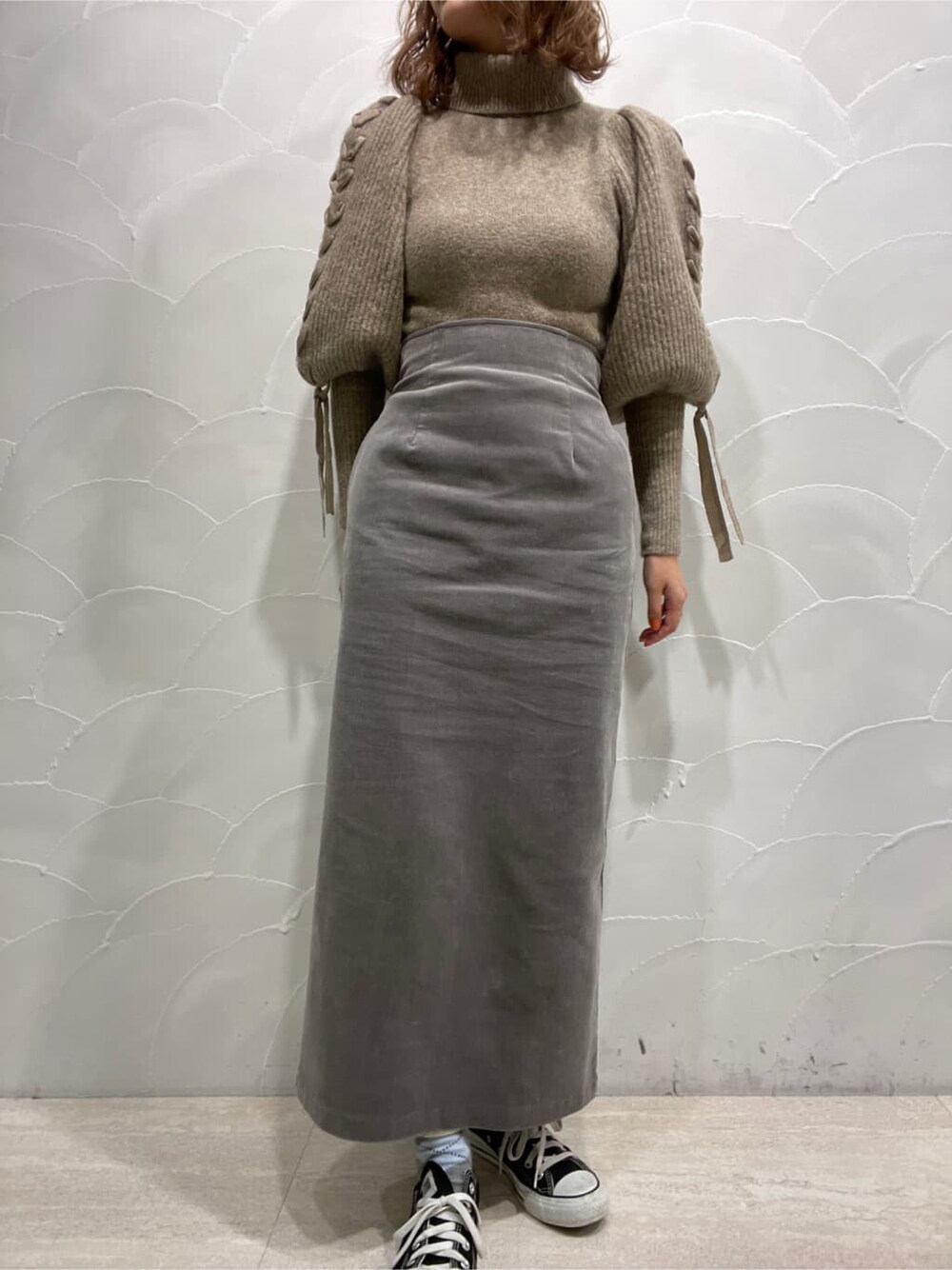 グレー系のスカート、ベージュ系のニット/セーターを着用したレディースの冬コーディネートの8枚目の写真