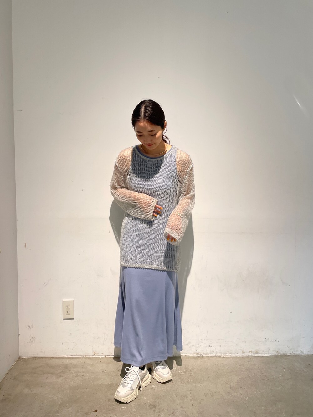 ホワイト系のスニーカー、ブルー系のニット/セーター、ブルー系のワンピースを着用したレディースの春コーディネートの2枚目の写真