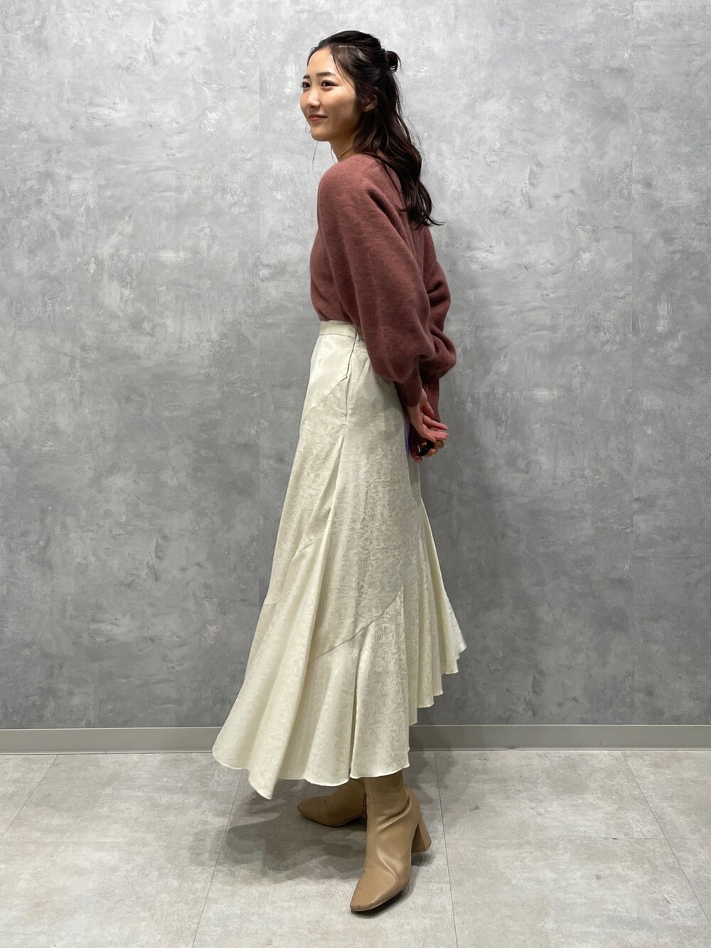 ベージュ系のブーツ、ホワイト系のスカート、ピンク系のニット/セーターを着用したレディースの冬コーディネートの4枚目の写真