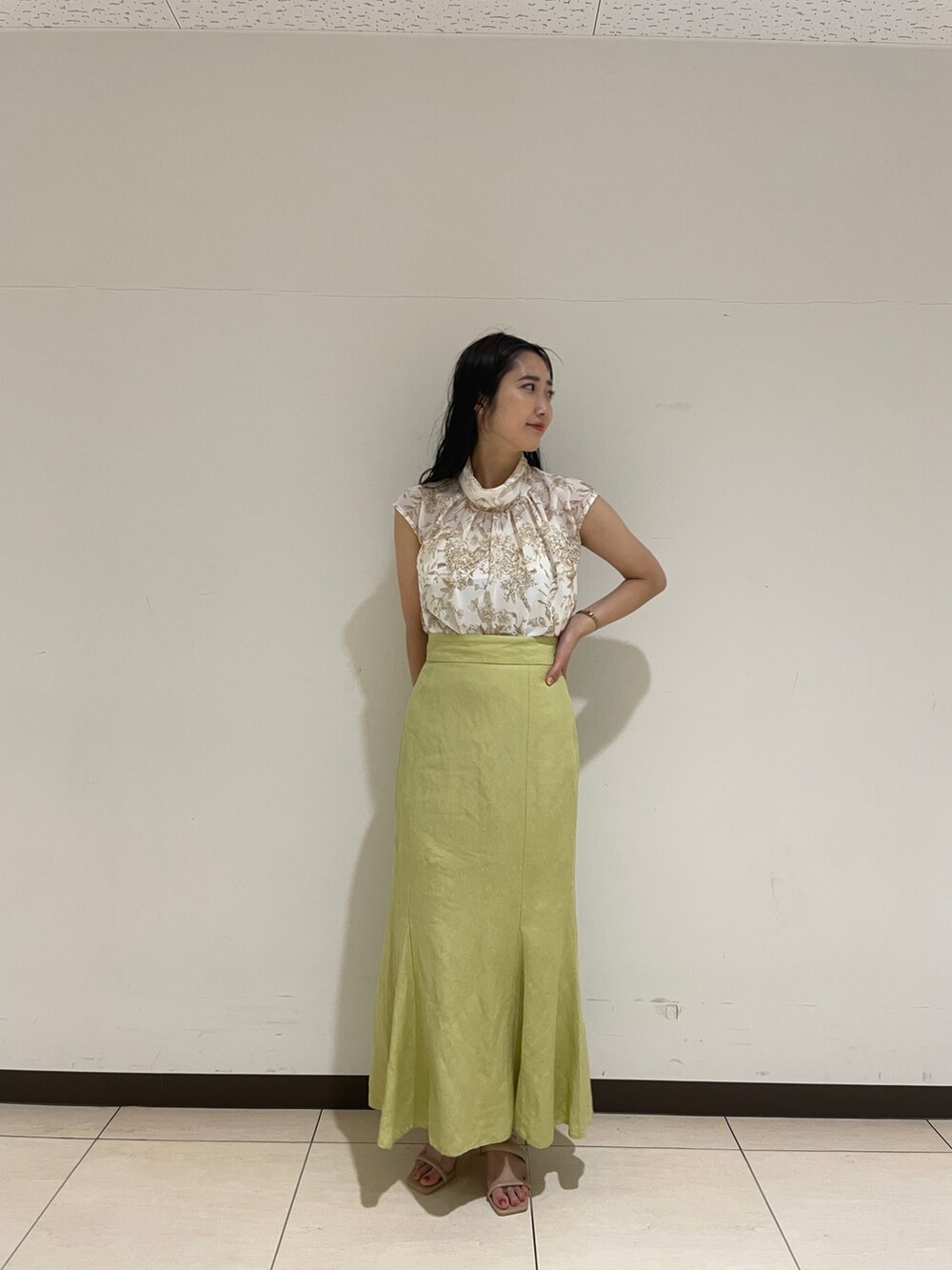 ベージュ系のシャツ/ブラウス、グリーン系のスカート、ベージュ系のサンダルを着用したレディースの春コーディネートの4枚目の写真