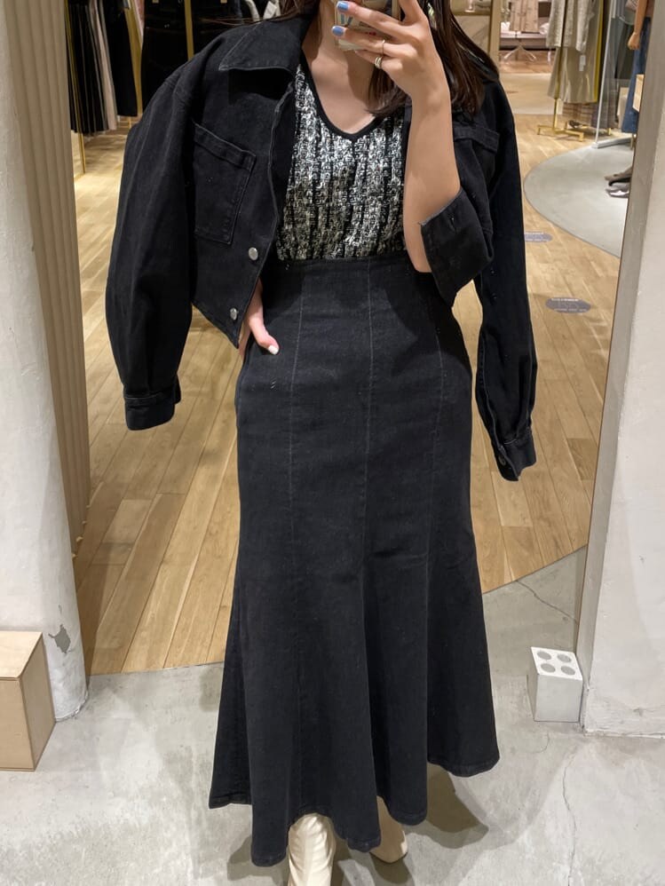 ブラック系のスカート、ブラック系のデニムジャケット、ブラック系のニット/セーターを着用したレディースの夏コーディネートの3枚目の写真