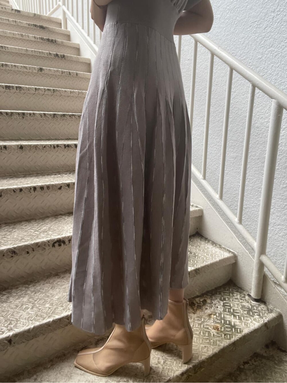 ベージュ系のトレンチコート、グレー系のワンピース、ベージュ系のブーツを着用したレディースの春コーディネートの10枚目の写真