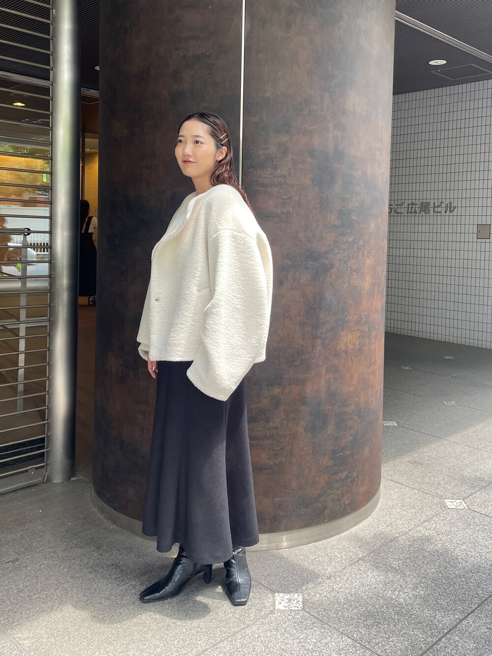 ブラック系のジャンパースカート、ピンク系のニット/セーター、ブラック系のブーツを着用したレディースの夏コーディネートの2枚目の写真