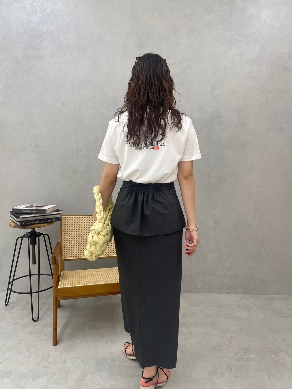 ベージュ系のハンドバッグ、ブラック系のサンダル、ホワイト系のTシャツ/カットソーを着用したレディースの春コーディネートの7枚目の写真