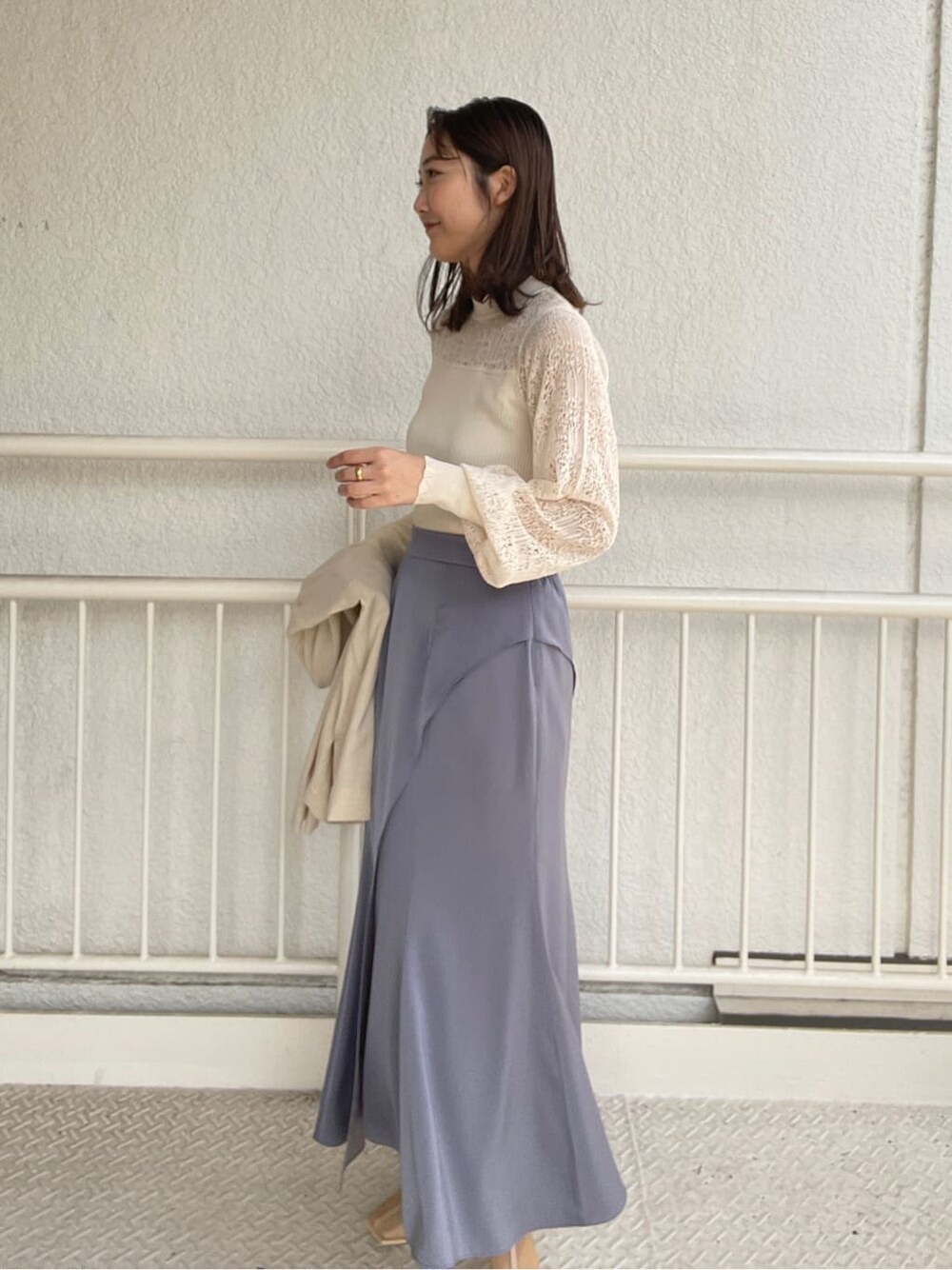 ホワイト系のニット/セーター、ベージュ系のブーツ、ブルー系のスカートを着用したレディースの春コーディネートの7枚目の写真
