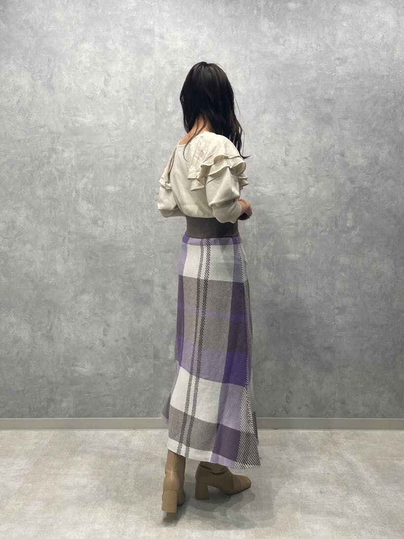 ベージュ系のブーツ、ホワイト系のニット/セーター、パープル系のスカートを着用したレディースの秋コーディネートの6枚目の写真