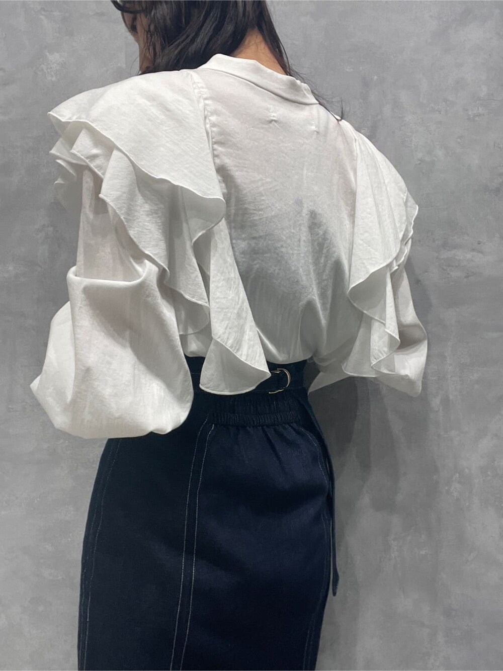 ブラック系のブーツ、ブルー系のスカート、ホワイト系のシャツ/ブラウスを着用したレディースの秋コーディネートの10枚目の写真