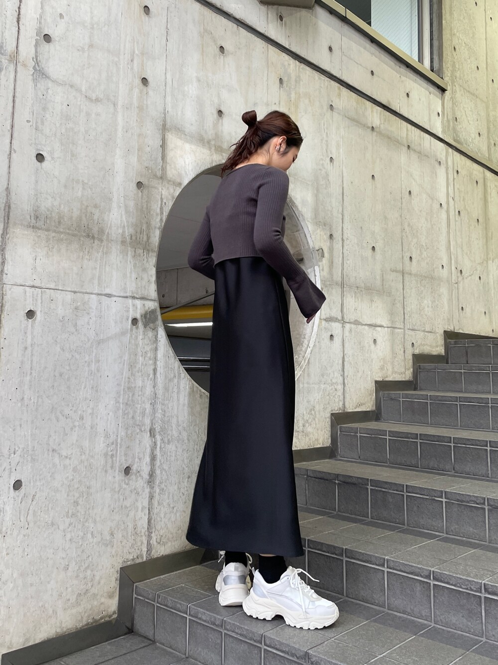 ホワイト系のスニーカー、ブラック系のワンピースを着用したレディースの冬コーディネートの5枚目の写真