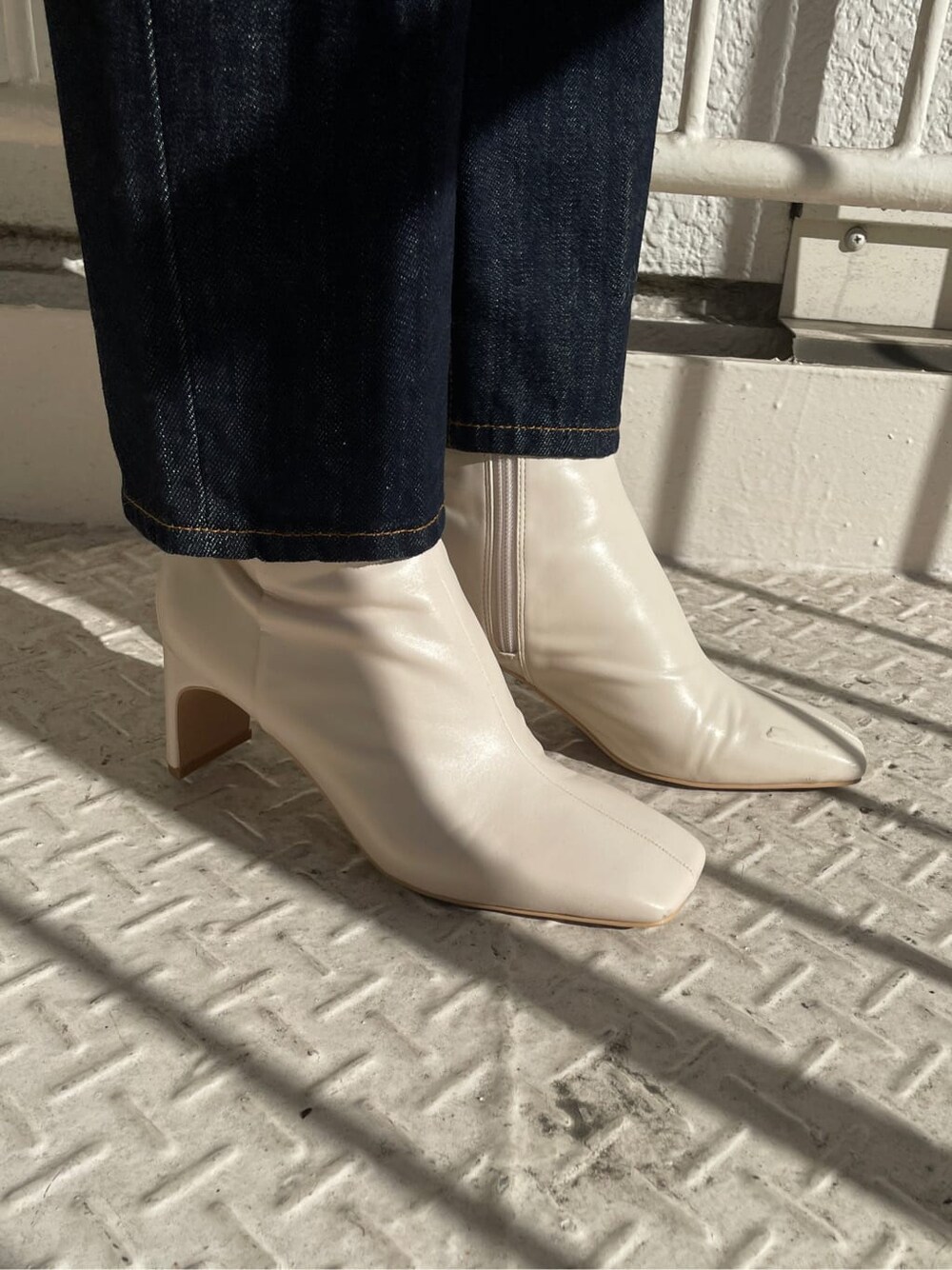 ホワイト系のその他シューズ、ブラウン系のニット/セーター、ブルー系のデニムパンツを着用したレディースの冬コーディネートの9枚目の写真