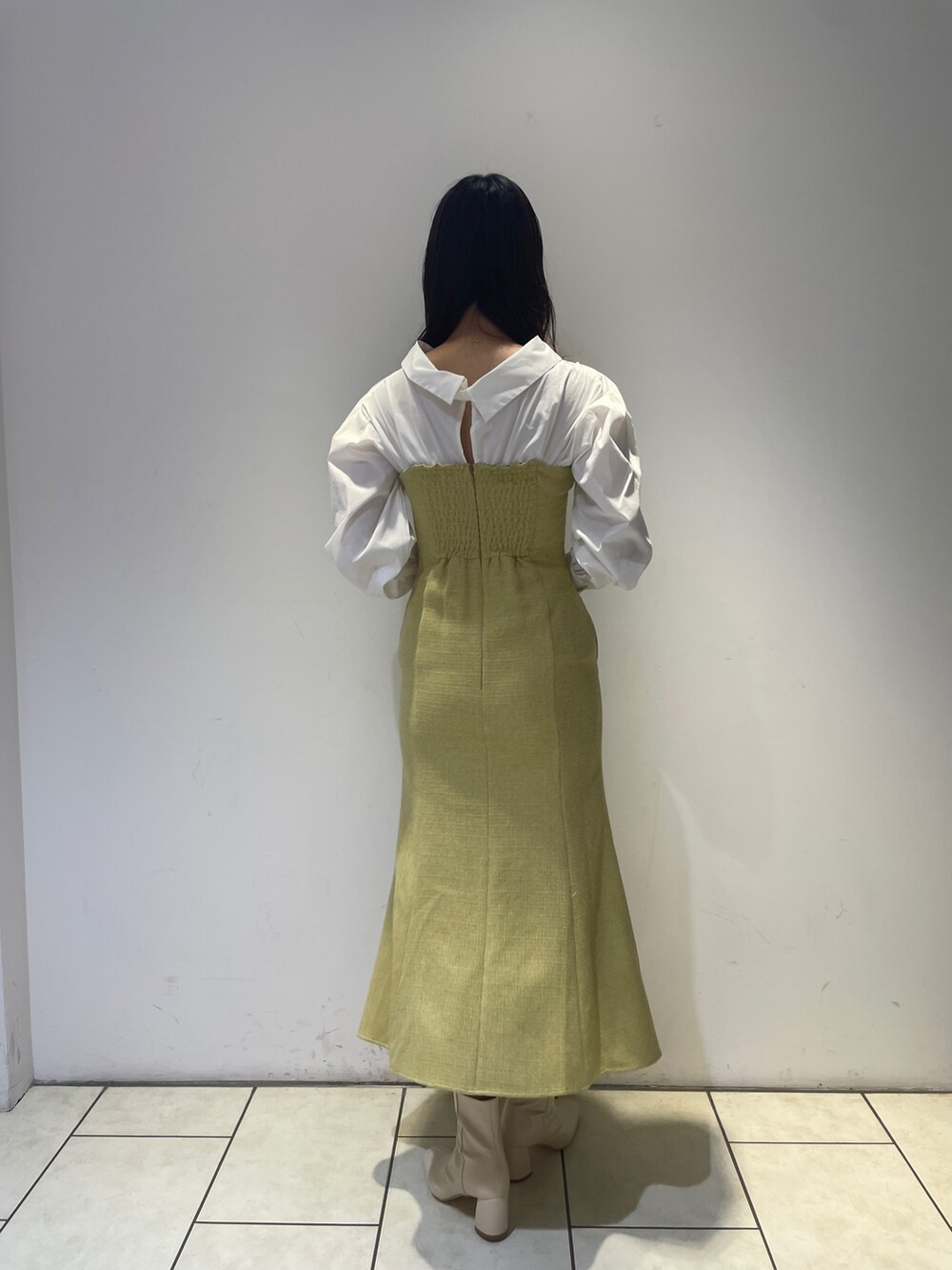 イエロー系のワンピース、ホワイト系のブーツを着用したレディースの秋コーディネートの6枚目の写真