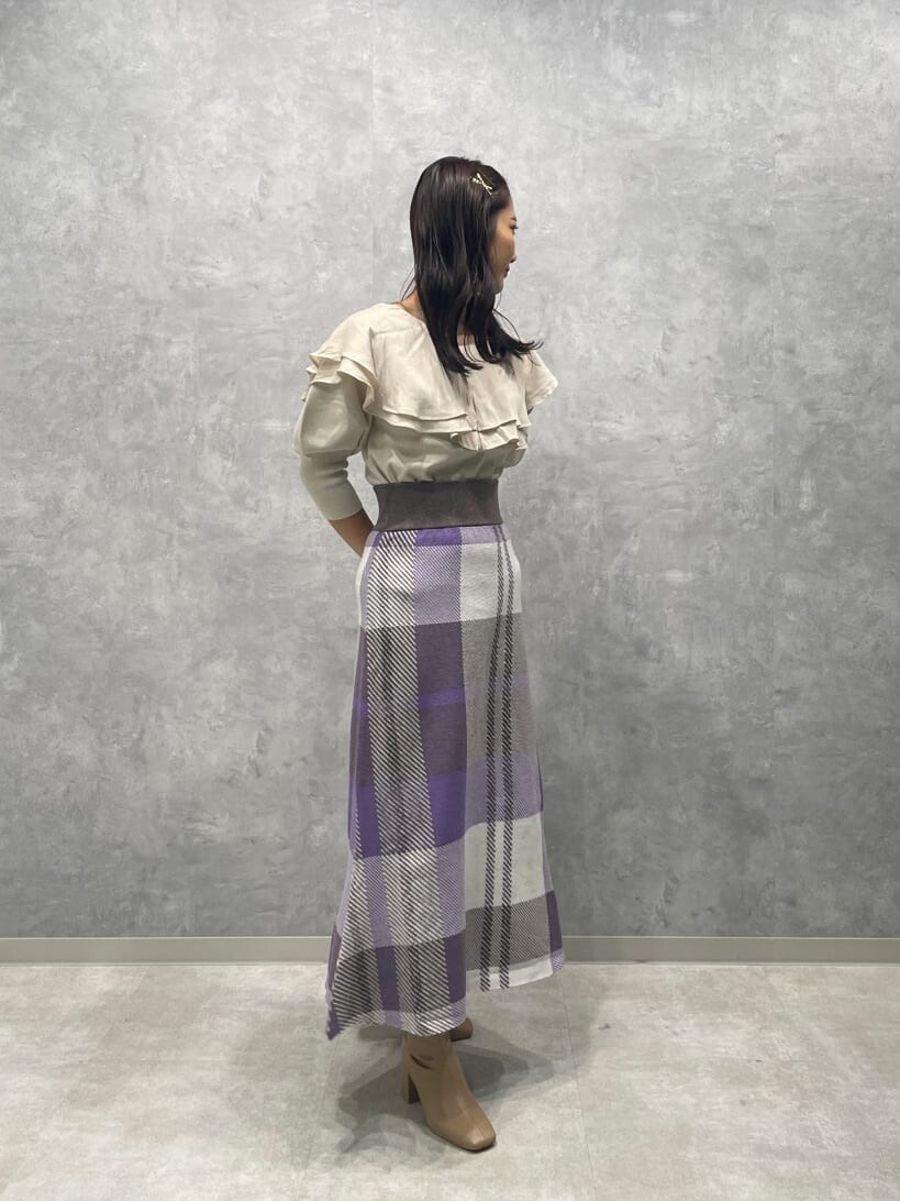 ベージュ系のブーツ、ホワイト系のニット/セーター、パープル系のスカートを着用したレディースの秋コーディネートの4枚目の写真