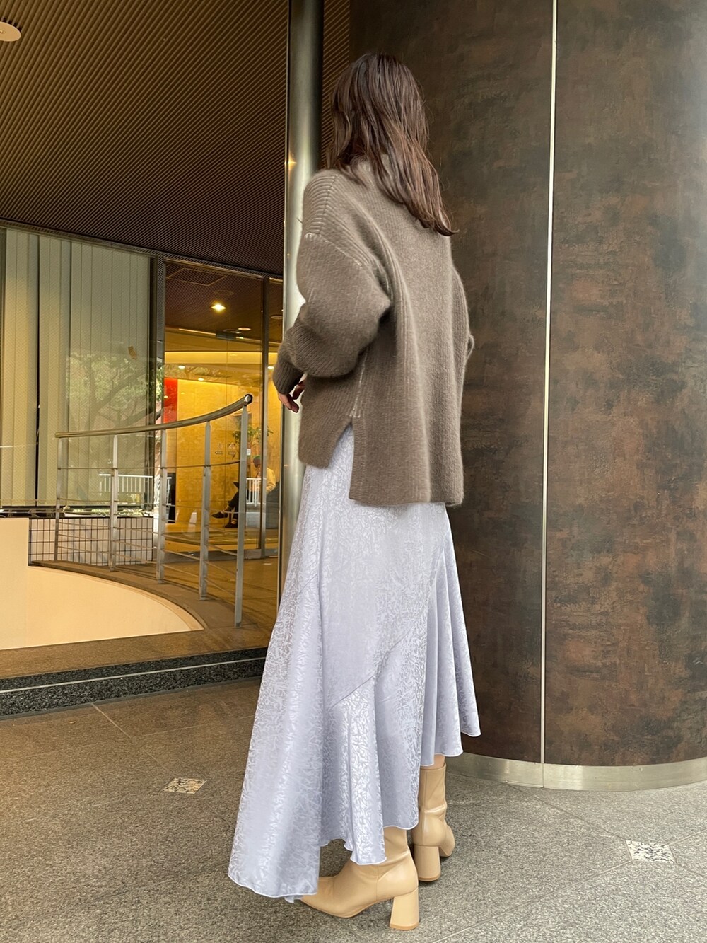 ベージュ系のニット/セーター、ベージュ系のブーツ、ブラック系のその他アウターを着用したレディースの冬コーディネートの8枚目の写真