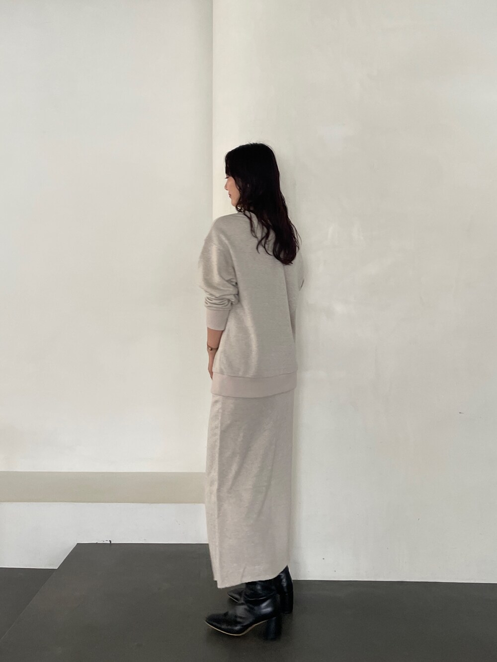 ブラック系のブーツ、ベージュ系のスカート、ベージュ系のスウェットを着用したレディースの秋コーディネートの4枚目の写真